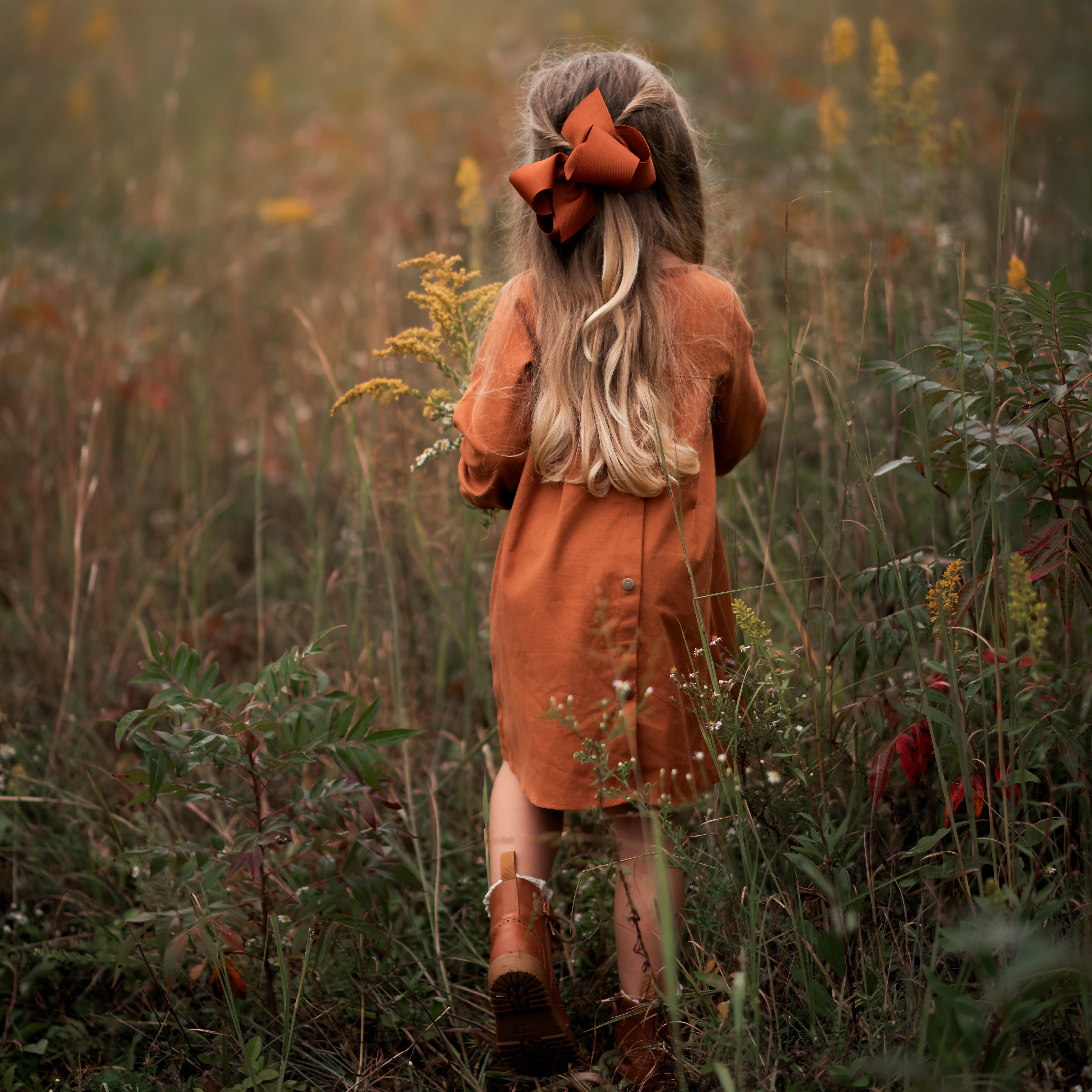 Model girl showcasing the back view of the dress - This image focuses on the back of the dress, showcasing the pleated yoke and how it complements the overall design.