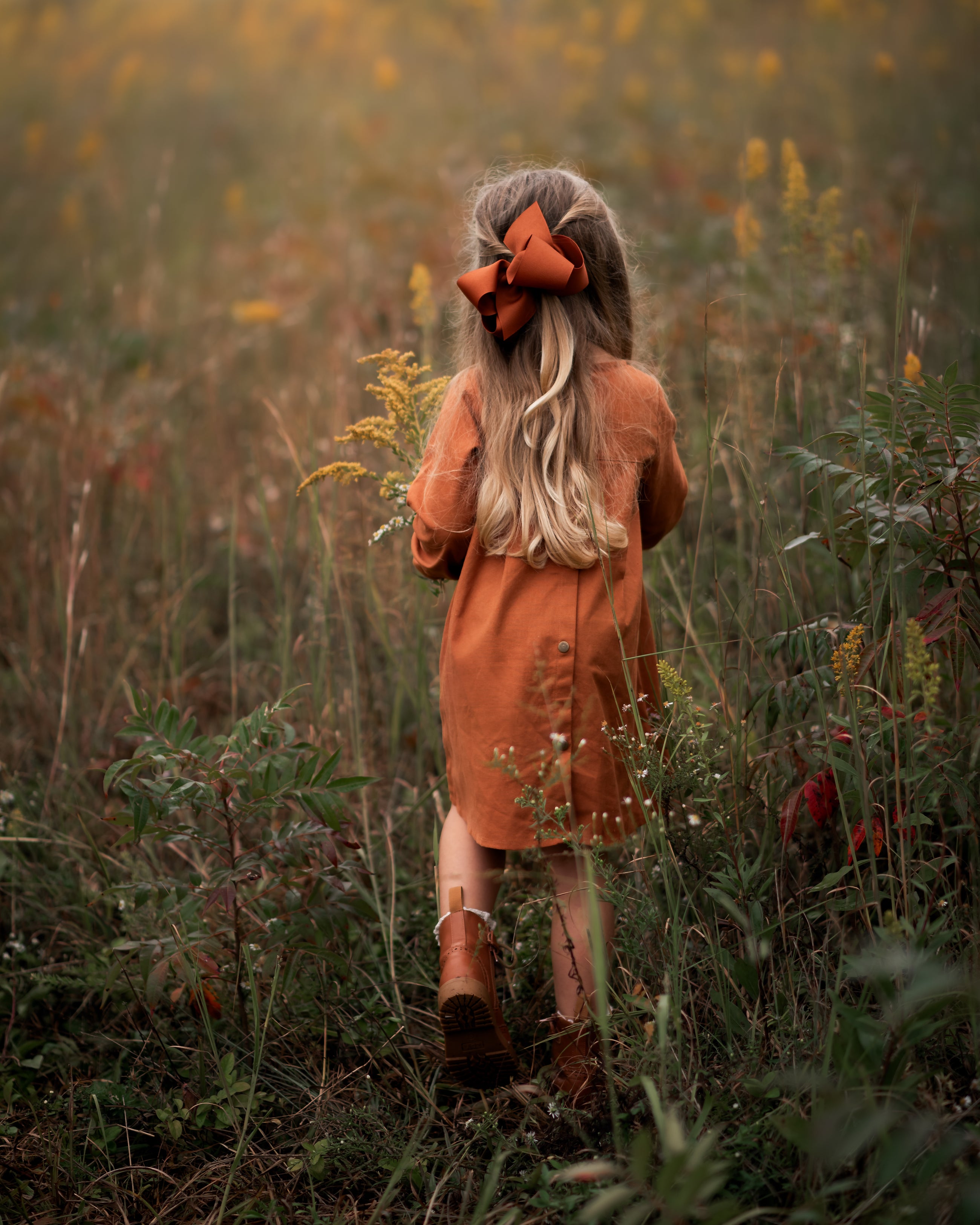 Model girl showcasing the back view of the dress - This image focuses on the back of the dress, showcasing the pleated yoke and how it complements the overall design.