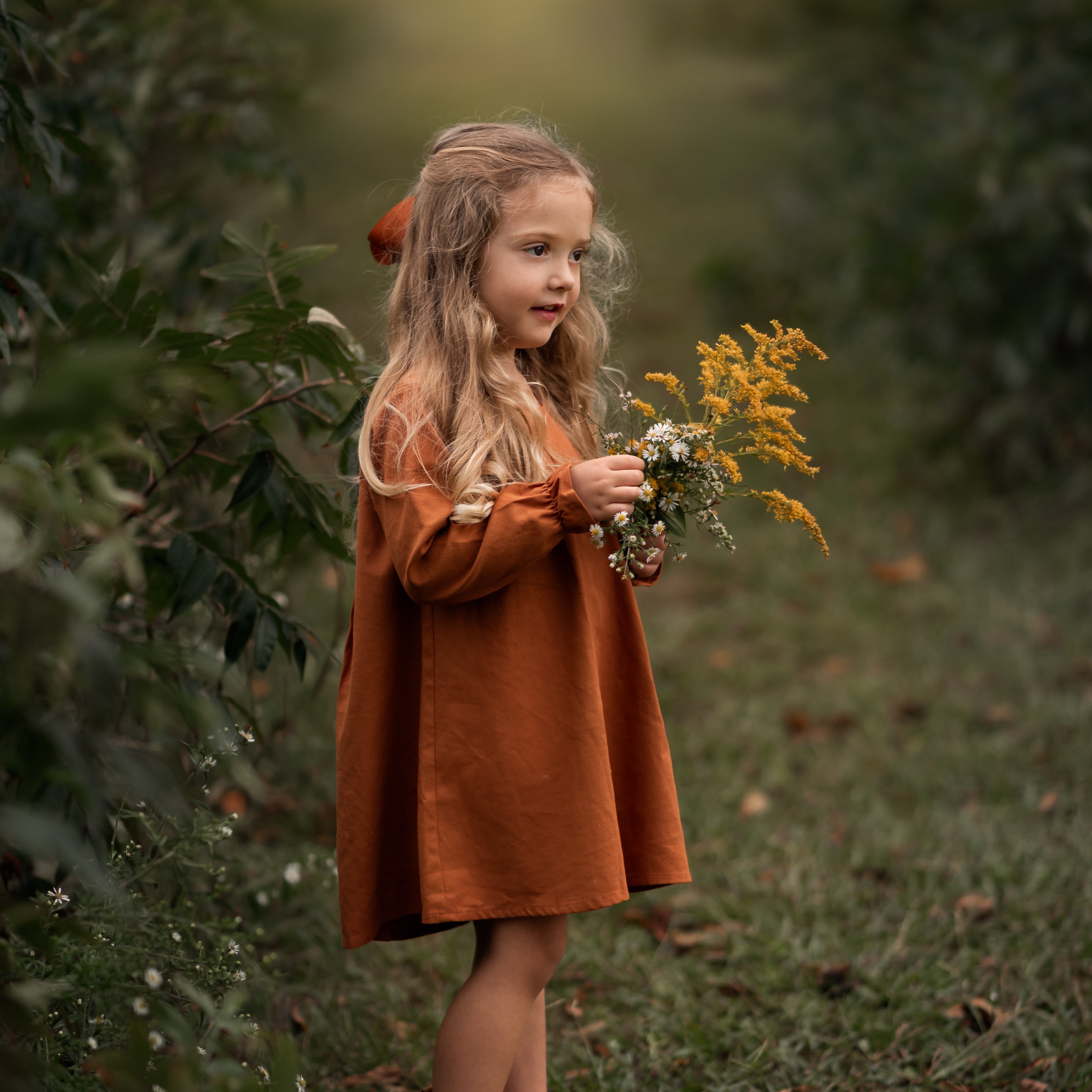 Model girl showcasing the side view of the dress - This side angle captures the dress’s flow and movement, emphasizing the ruffled hem at the sleeves and the overall fit.