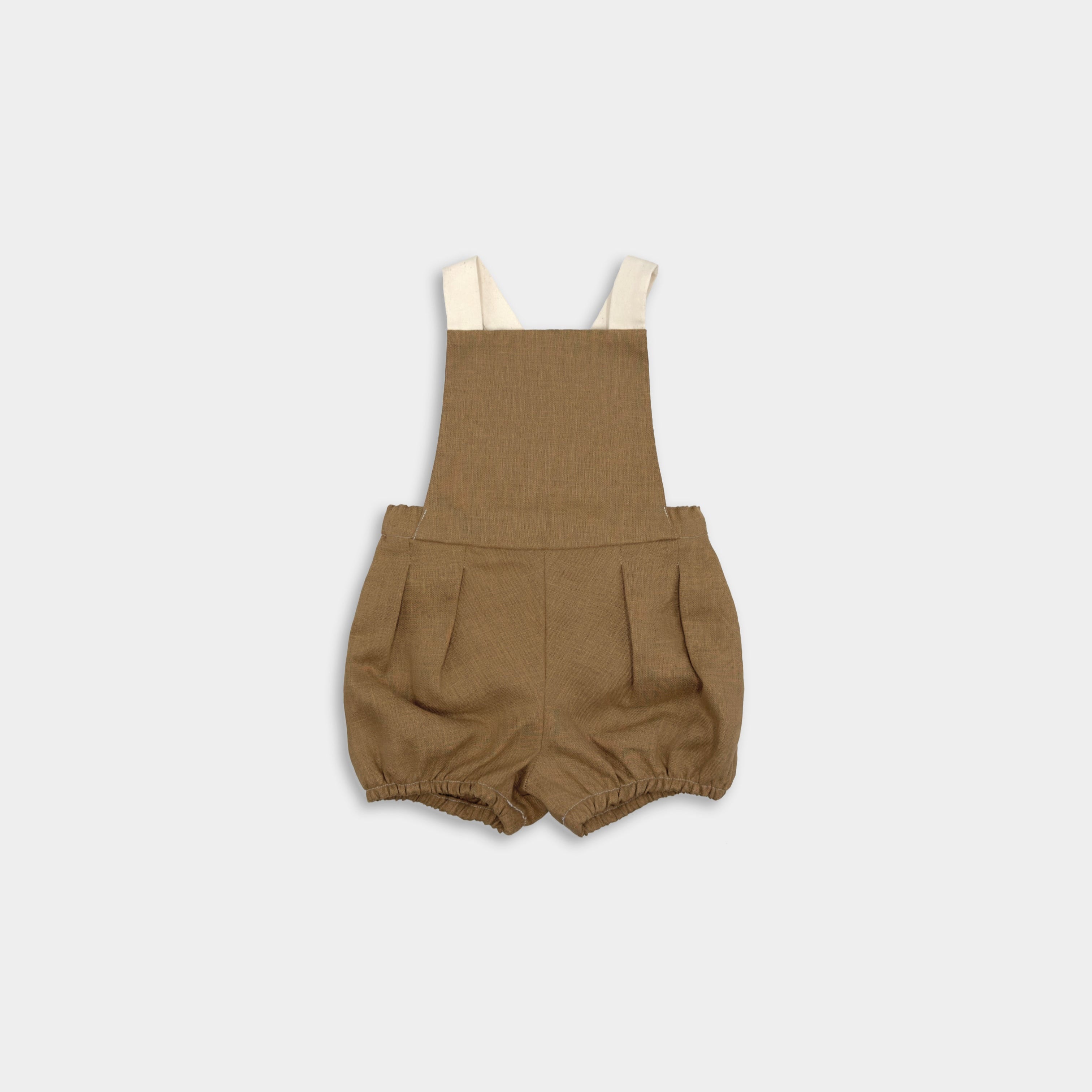 Front view of a handmade linen bubble romper in Beachwood, featuring adjustable contrasting straps in cream for a customizable fit and elasticized legs for easy movement during summer play. A gender-neutral design that combines timeless style with comfort, perfect for any occasion.