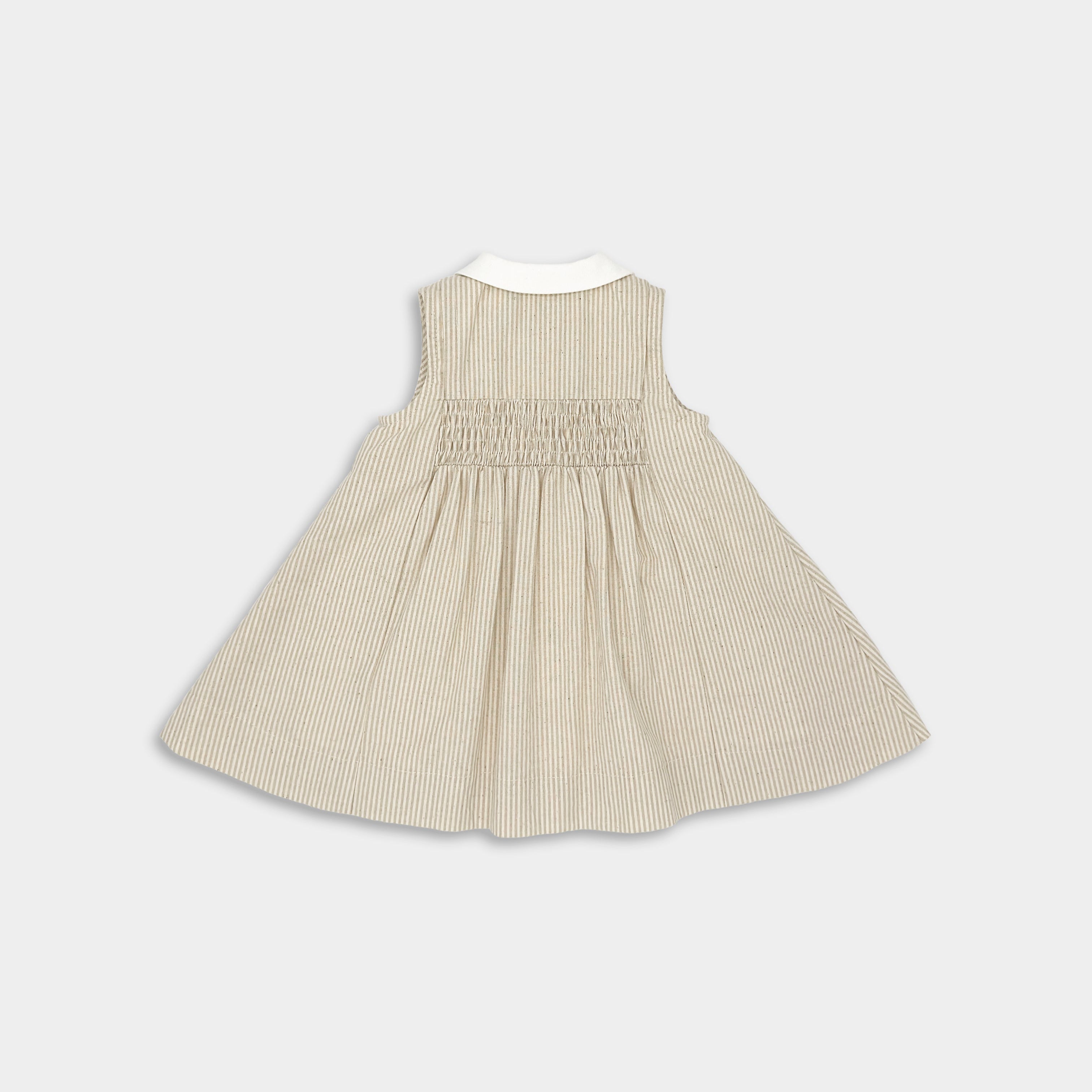 Back view of Beige Stripes Dress designed for little girls, featuring vintage-inspired sleeveless style, white contrasting collar and button placket, adorable smocking and pleat accents, quick Antique Brass lead-free snap closure, playful above-the-knee length, fully lined with 100% cotton for comfort, and pre-washed to maintain shape and minimize shrinking, blending fun and elegance in sustainable children's wear.