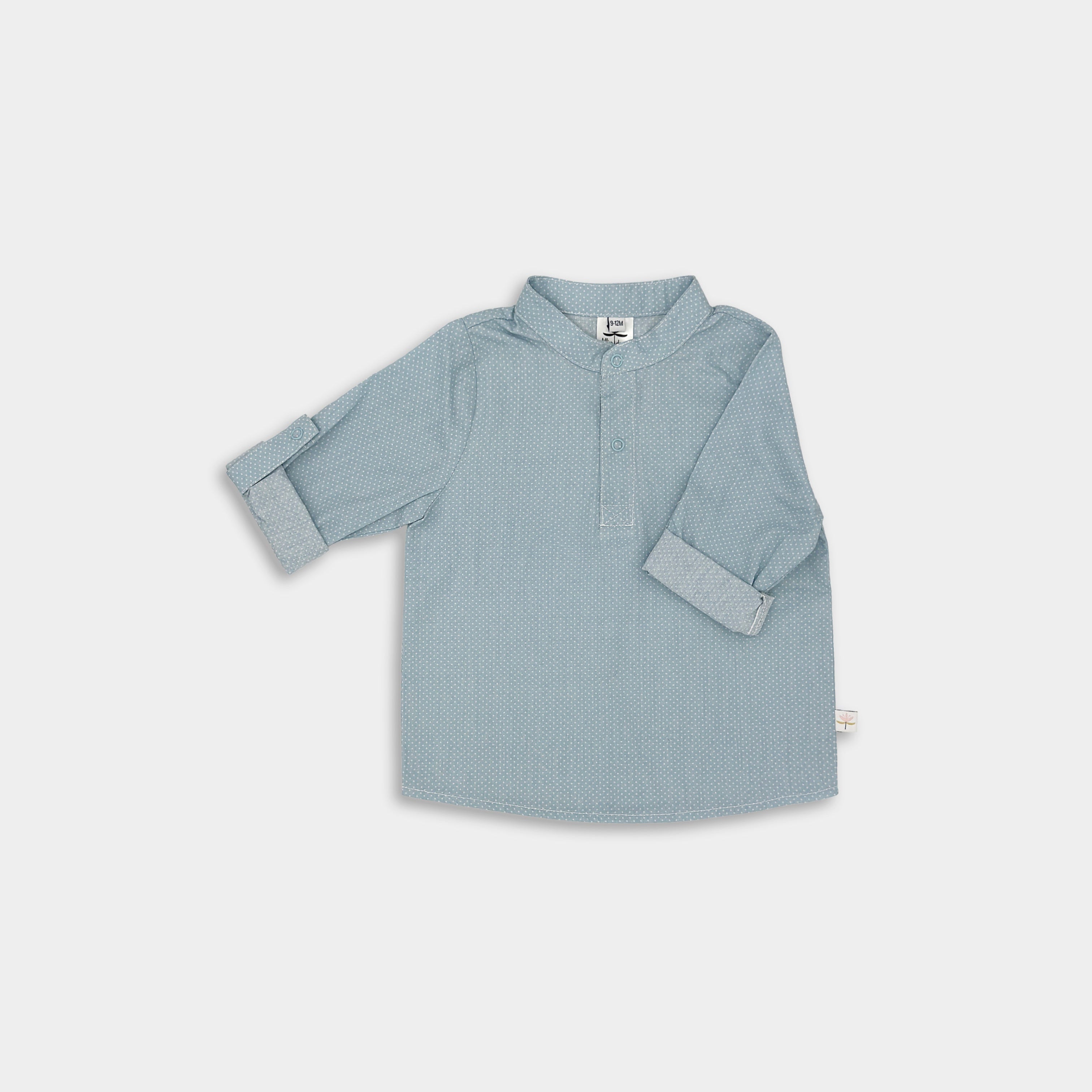 Front view of a classic light blue Henley shirt featuring white Swiss dots, crafted from natural, sustainable, and high-quality materials. It includes a timeless Henley placket for versatile wear and 3/4 cuffed sleeves that can be easily unrolled for layering, offering a stylish and functional addition to any outfit.