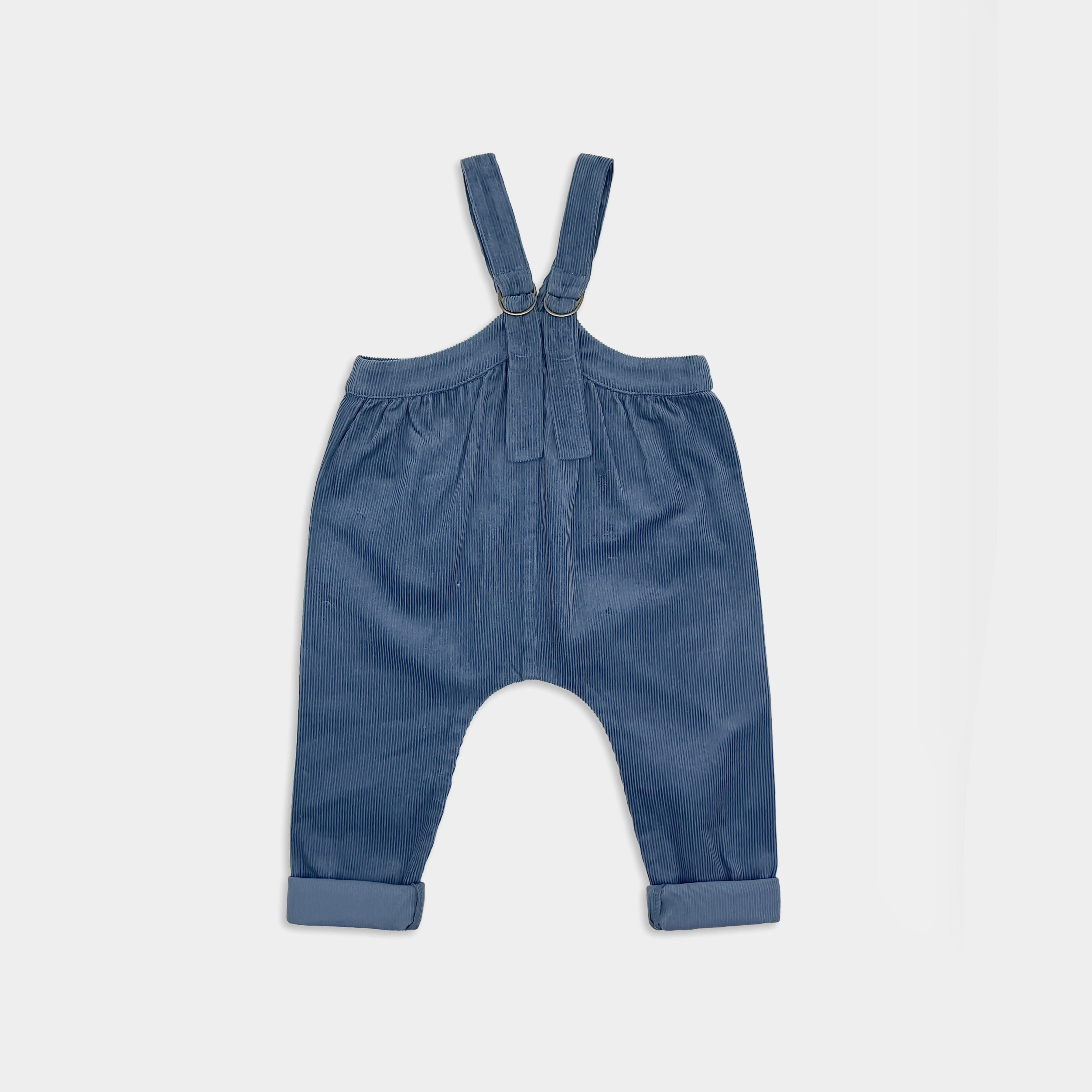 Blue denim corduroy baby overalls on a light gray background