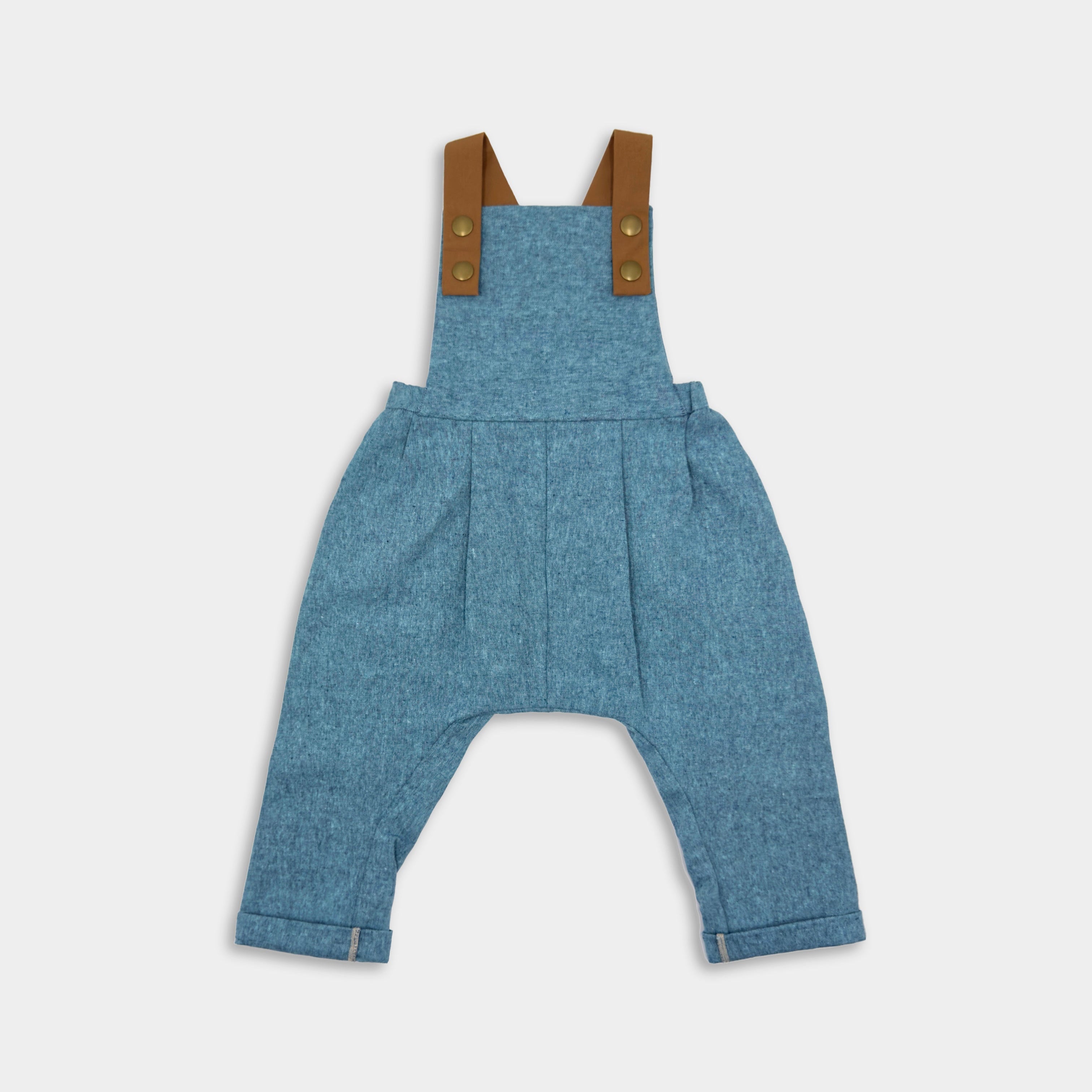 Blue Jay Long Overalls - Handmade from repurposed linen fabric, these gender-neutral overalls are perfect for passing down. The breathable fabric ensures all-day comfort, while stylish pleats add elegance to the design. Featuring leather-looking straps for enhanced durability and visual appeal, adjustable straps in two lengths provide a perfect fit. Unfoldable leg cuffs are designed to grow with your little one, making these overalls a versatile and sustainable choice for any wardrobe.