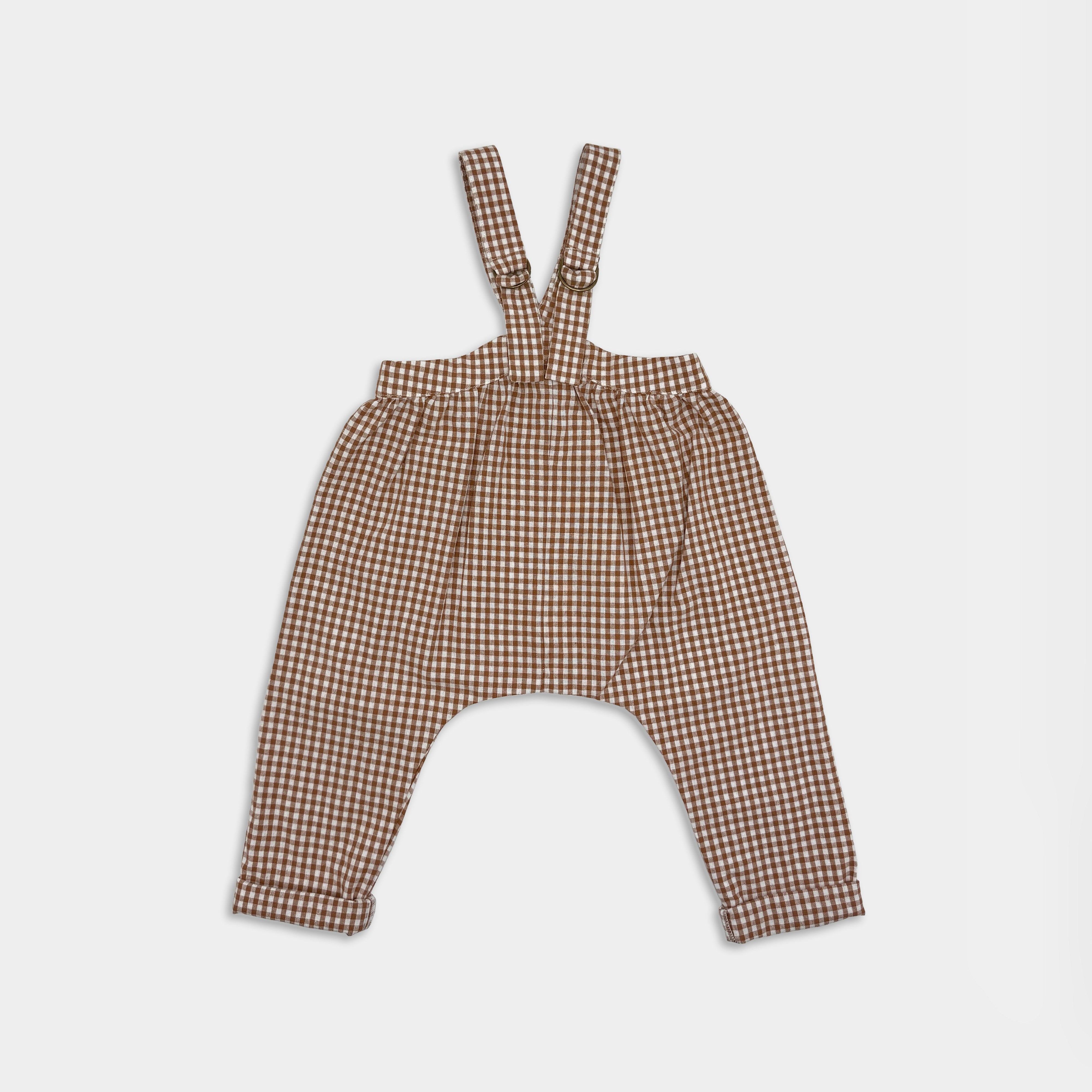Brown checkered back view of suspender pants for small kids on a light gray background
