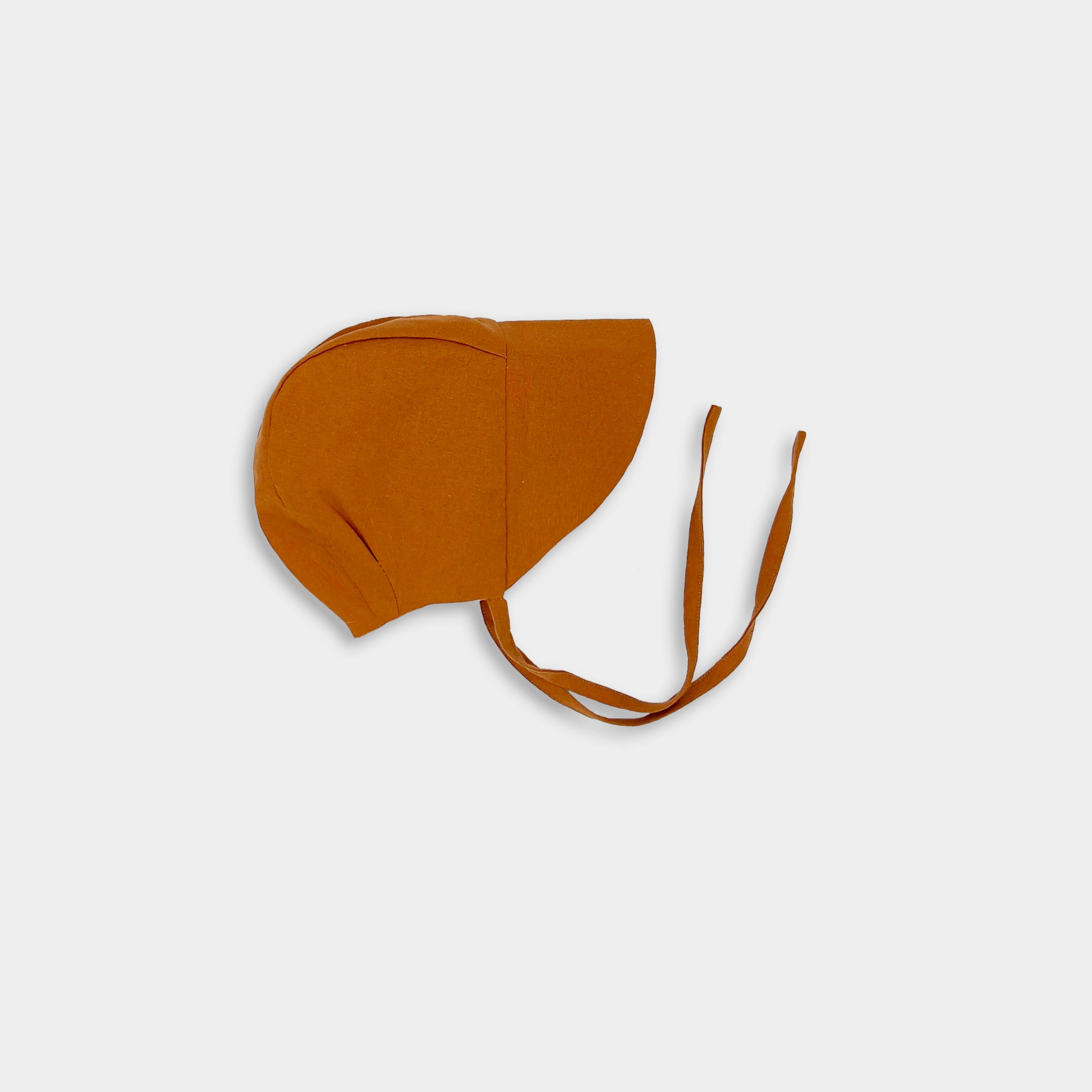 Photo of the Burnt Orange Sunbonnet with brim unfolded - This image captures the sunbonnet with the brim down, emphasizing its protective features against the sun while maintaining its classic look.