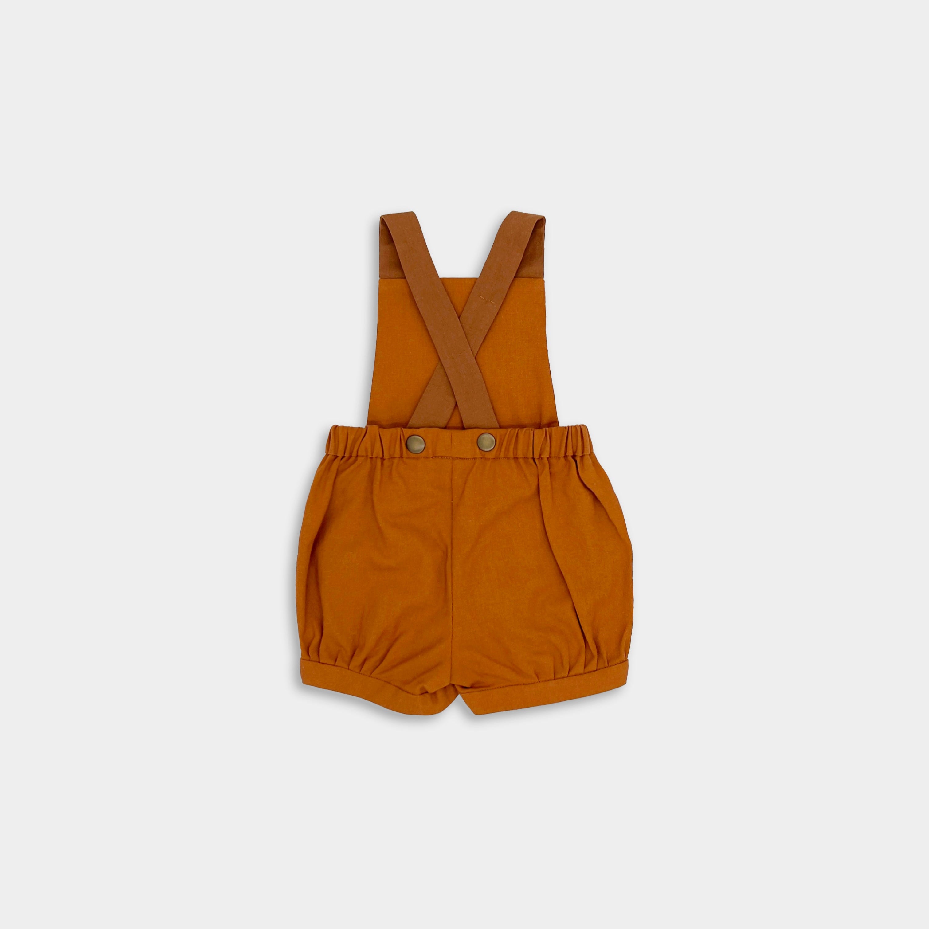 Back view of the Burnt Orange Short Overalls alone - Capturing the back of the shortalls, this image emphasizes the unique strap design and overall craftsmanship.