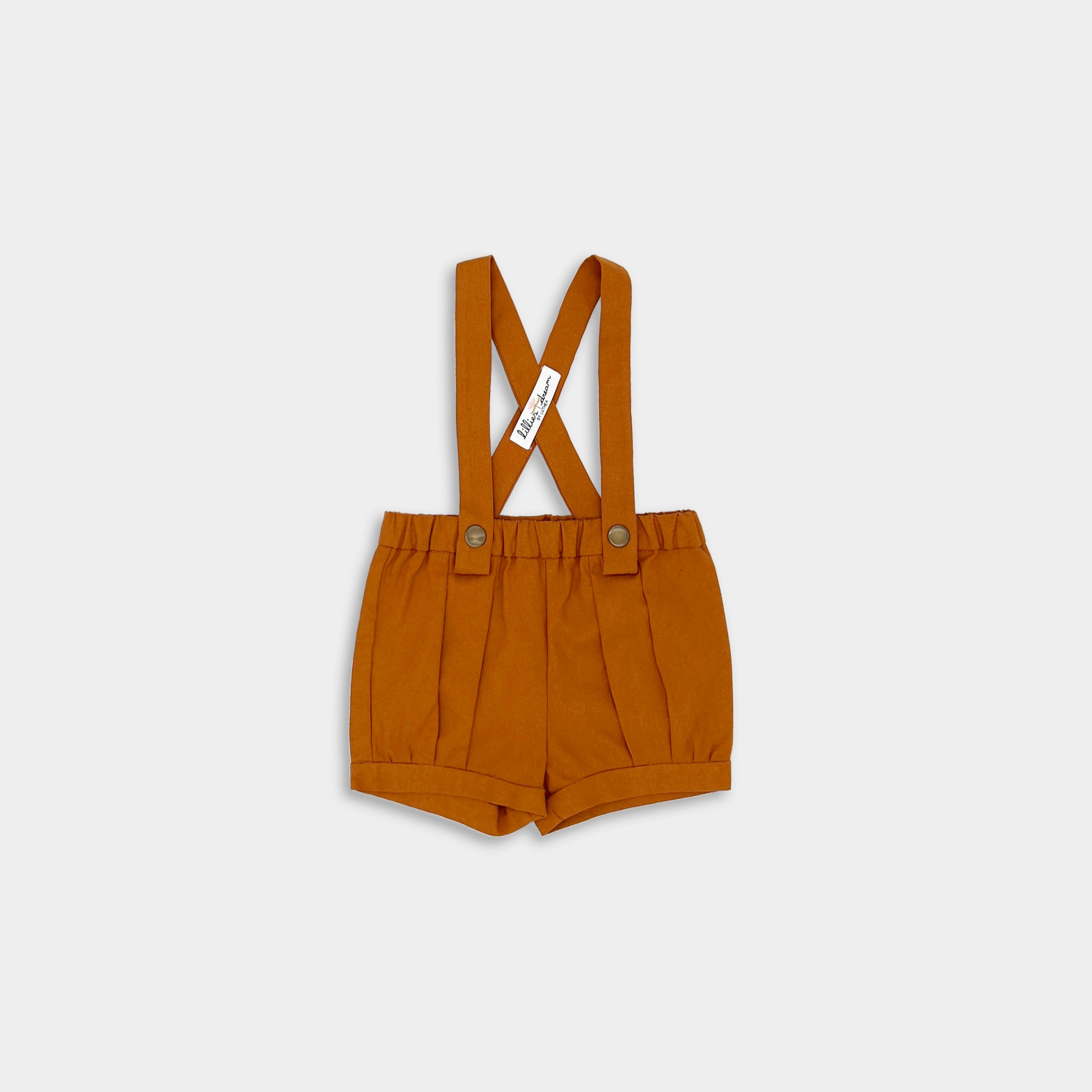 Photo of the Burnt Orange Suspender Shorts front view - This image showcases the front design of the suspender shorts, highlighting the adjustable straps, pleats, and cuffs for a stylish look.
