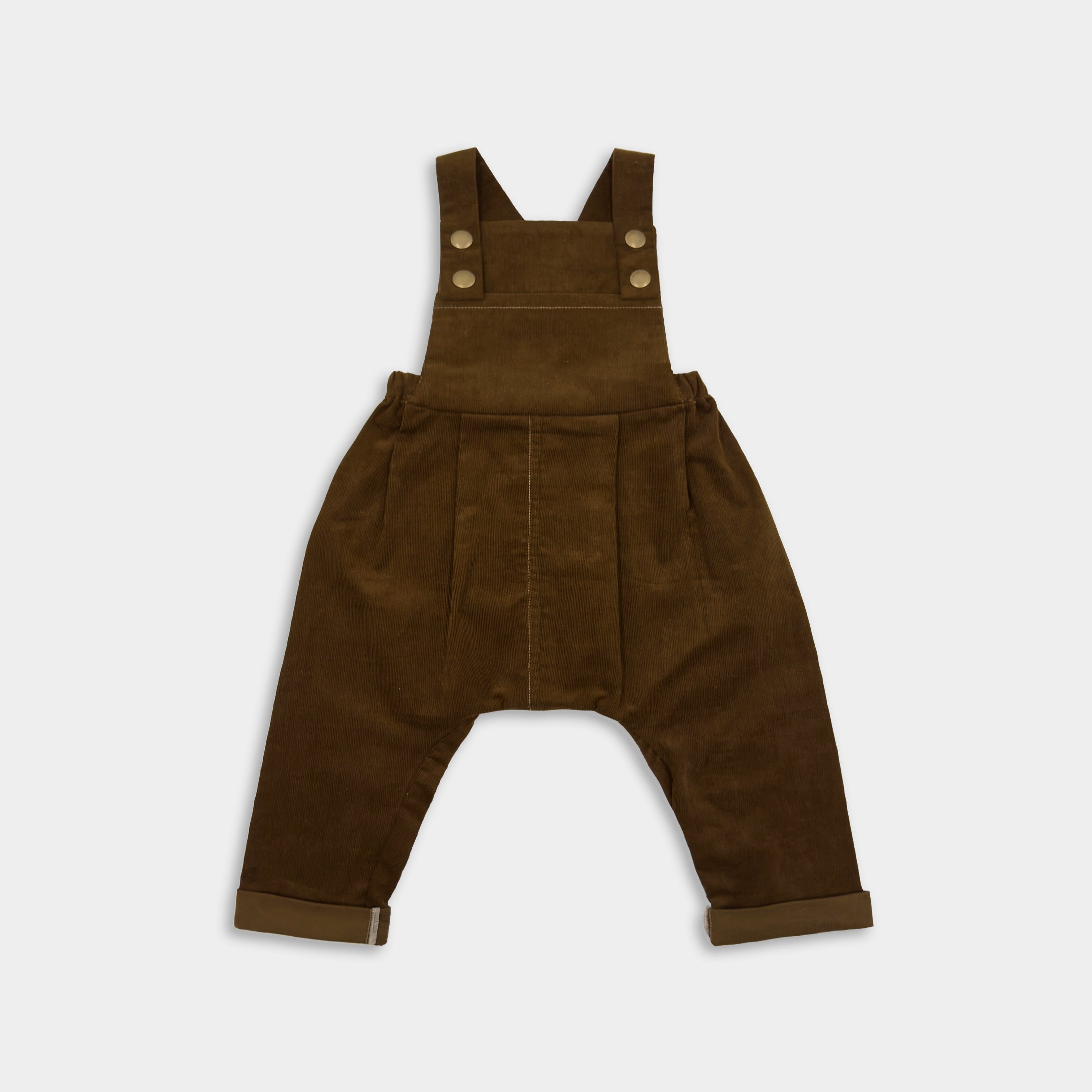Front view of cozy handmade cocoa brown long overalls, showcasing the spacious bib pocket and stylish pleats, designed for comfort and adventure in children’s wear.Front view of cozy cocoa brown long overalls, showcasing the spacious bib pocket and stylish pleats, designed for comfort and adventure in children’s wear.