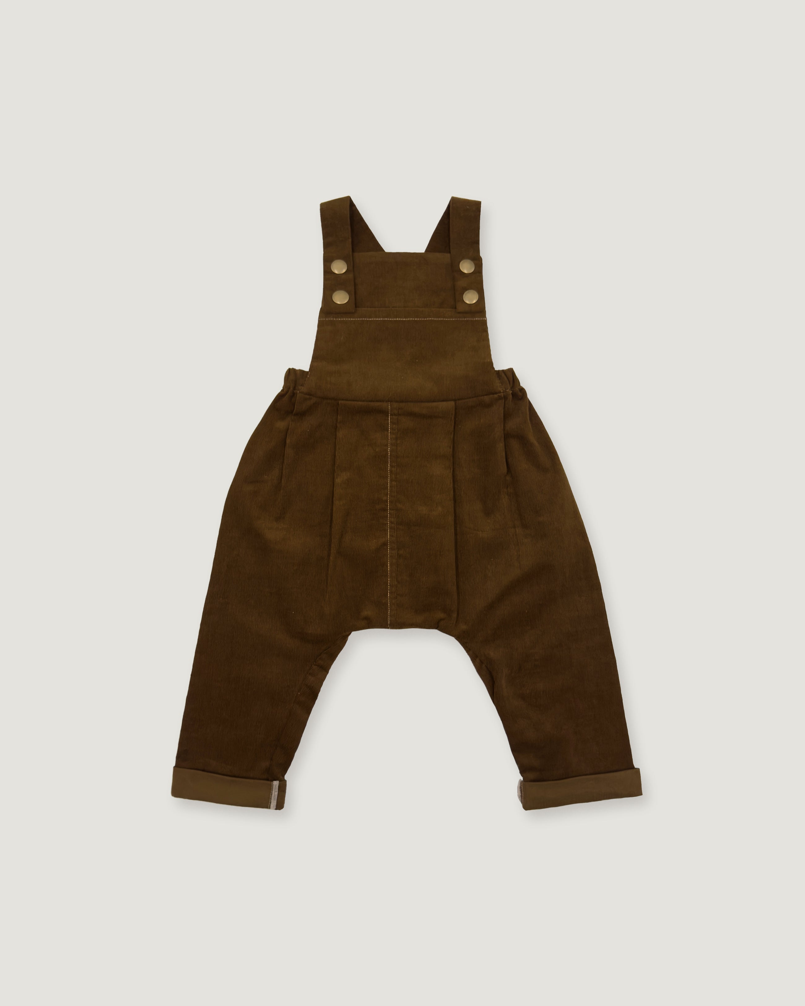 A pair of dark brown corduroy baby overalls with adjustable shoulder straps and four decorative buttons, laid flat against a light gray background.