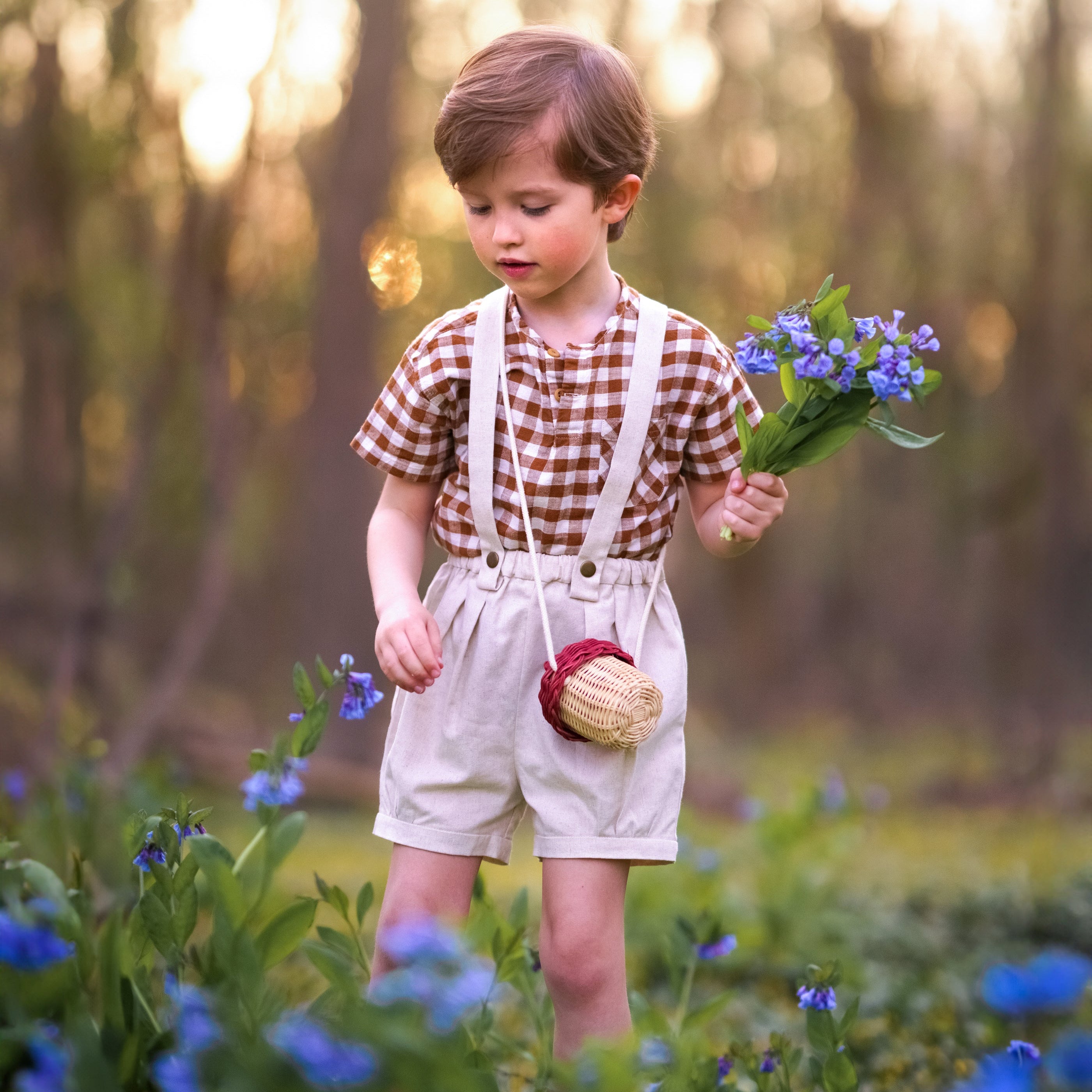 Child holding flowers in a field with a blurred natural background