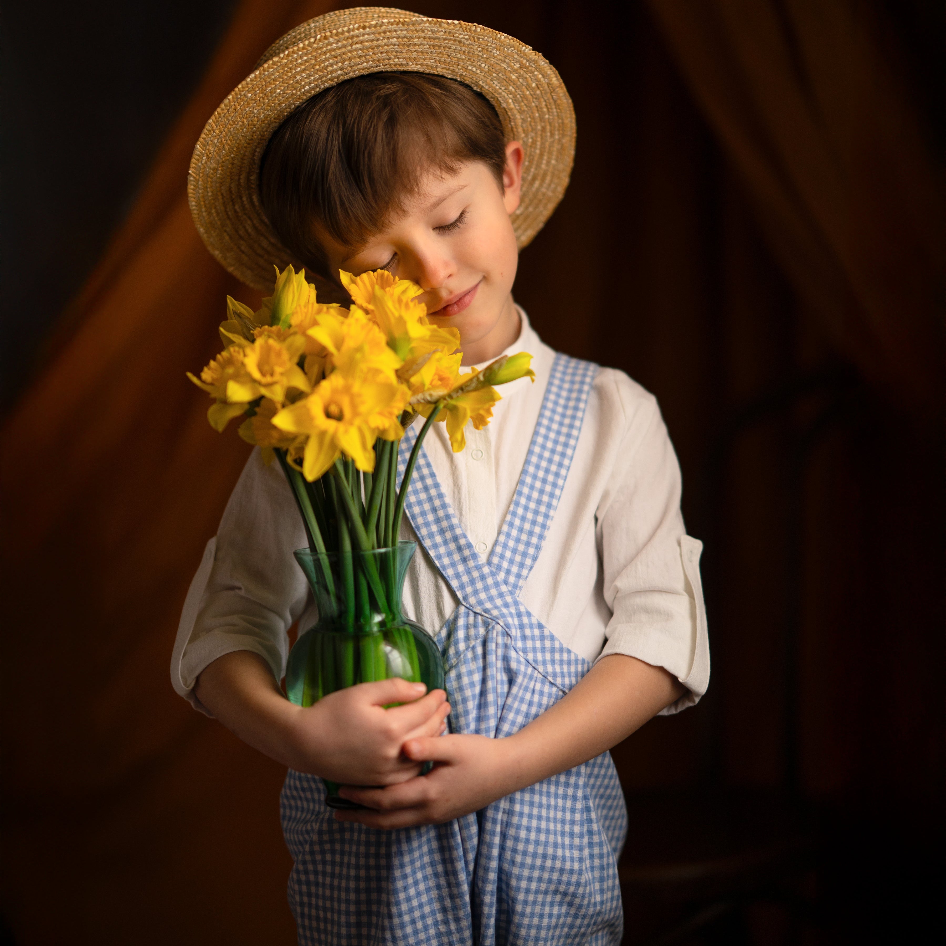 boy in blue gingham overalls with flowers