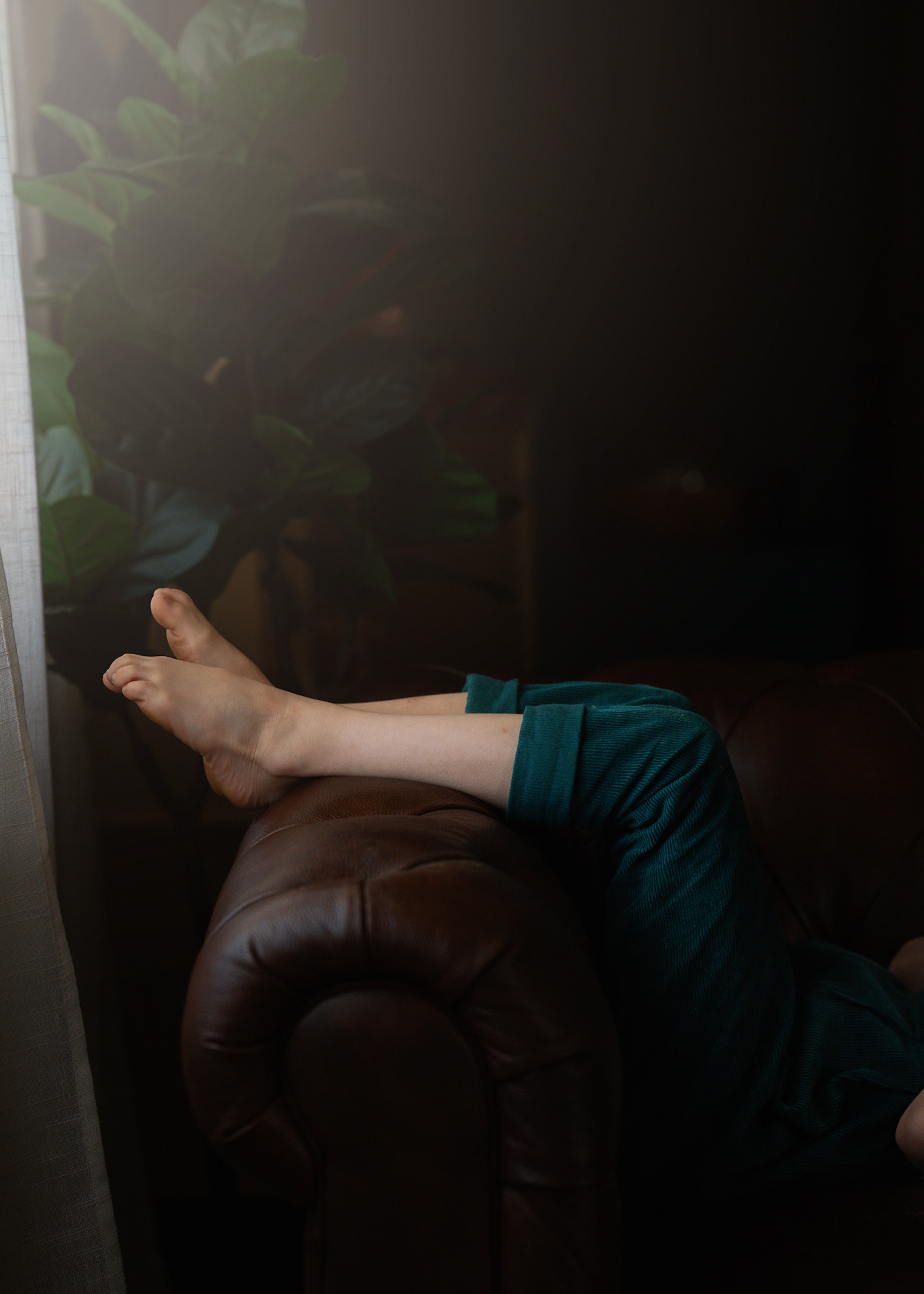 Person wearing green pants with feet visible on a dark background