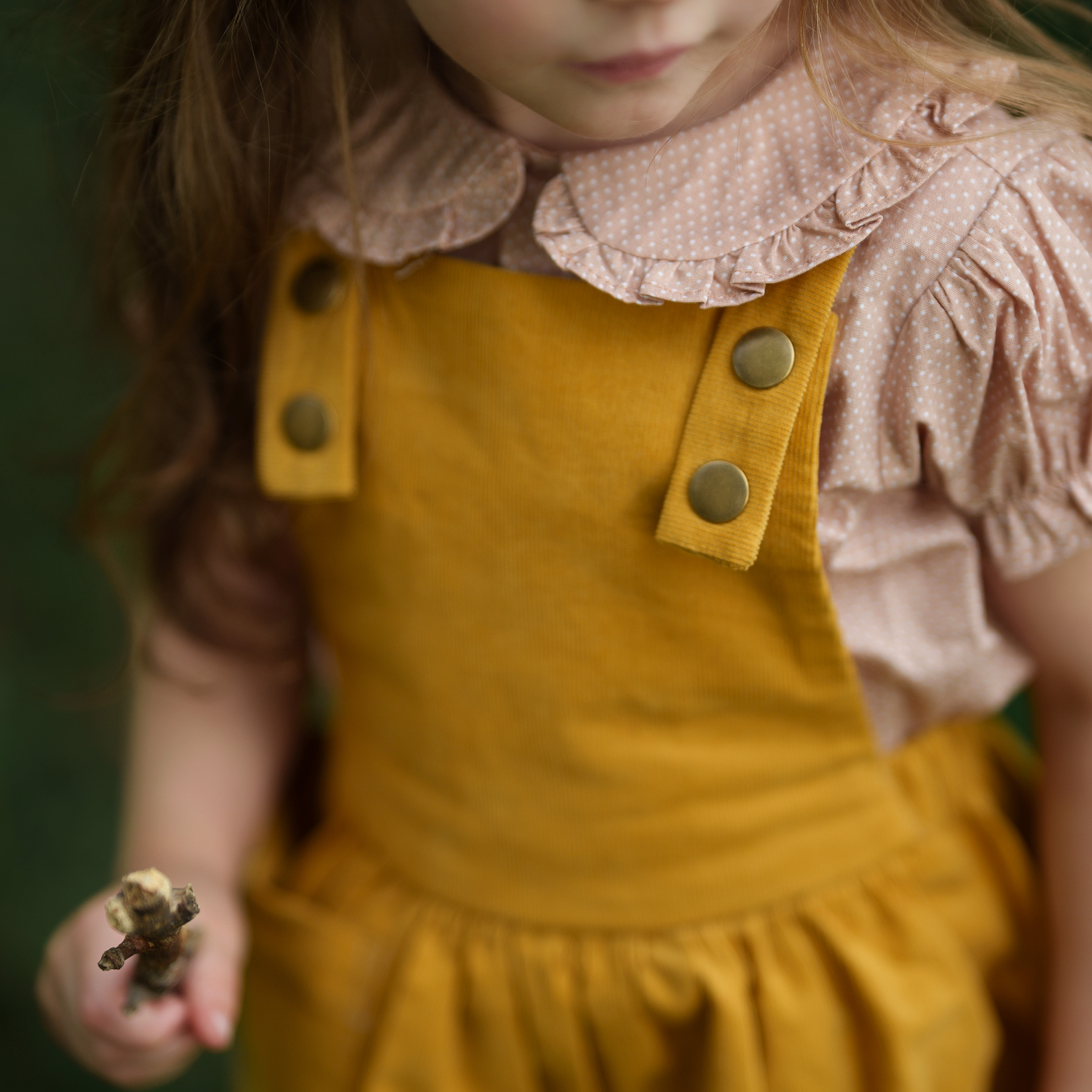 Close-up of the bib detail on the Mustard Pinafore, featuring a generous pocket designed for little treasures, showcasing the quality craftsmanship of our handmade children’s wear.