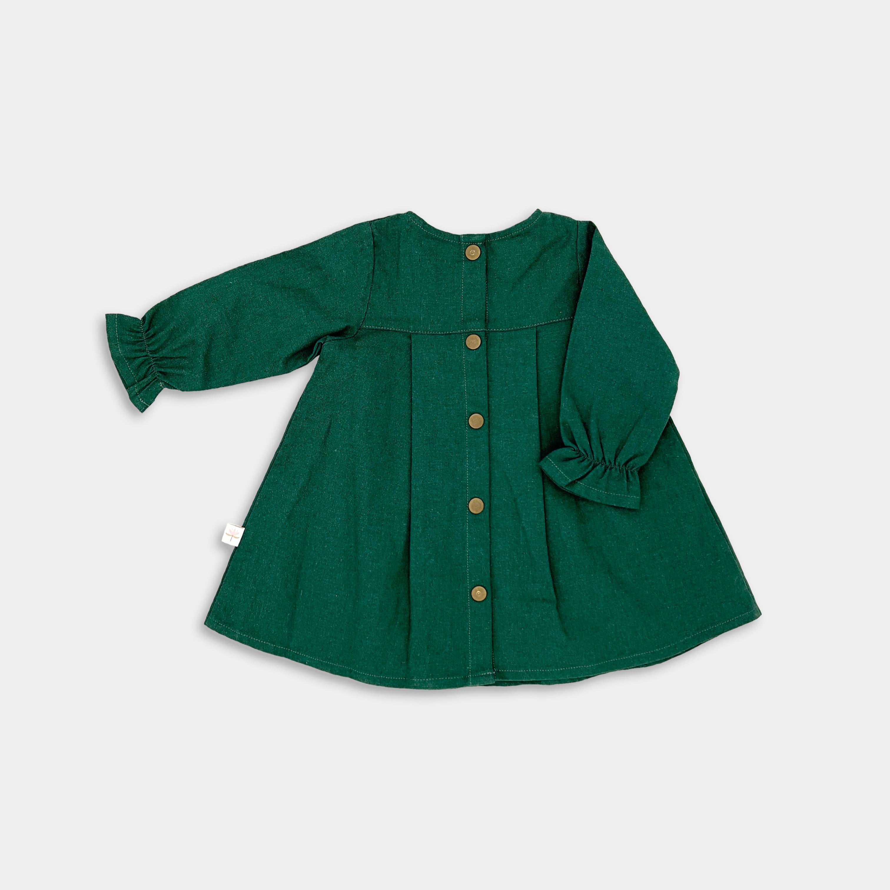 Back view of the evergreen linen dress displayed on its own, emphasizing the quality craftsmanship and elegant design that make it a timeless choice for little girls.