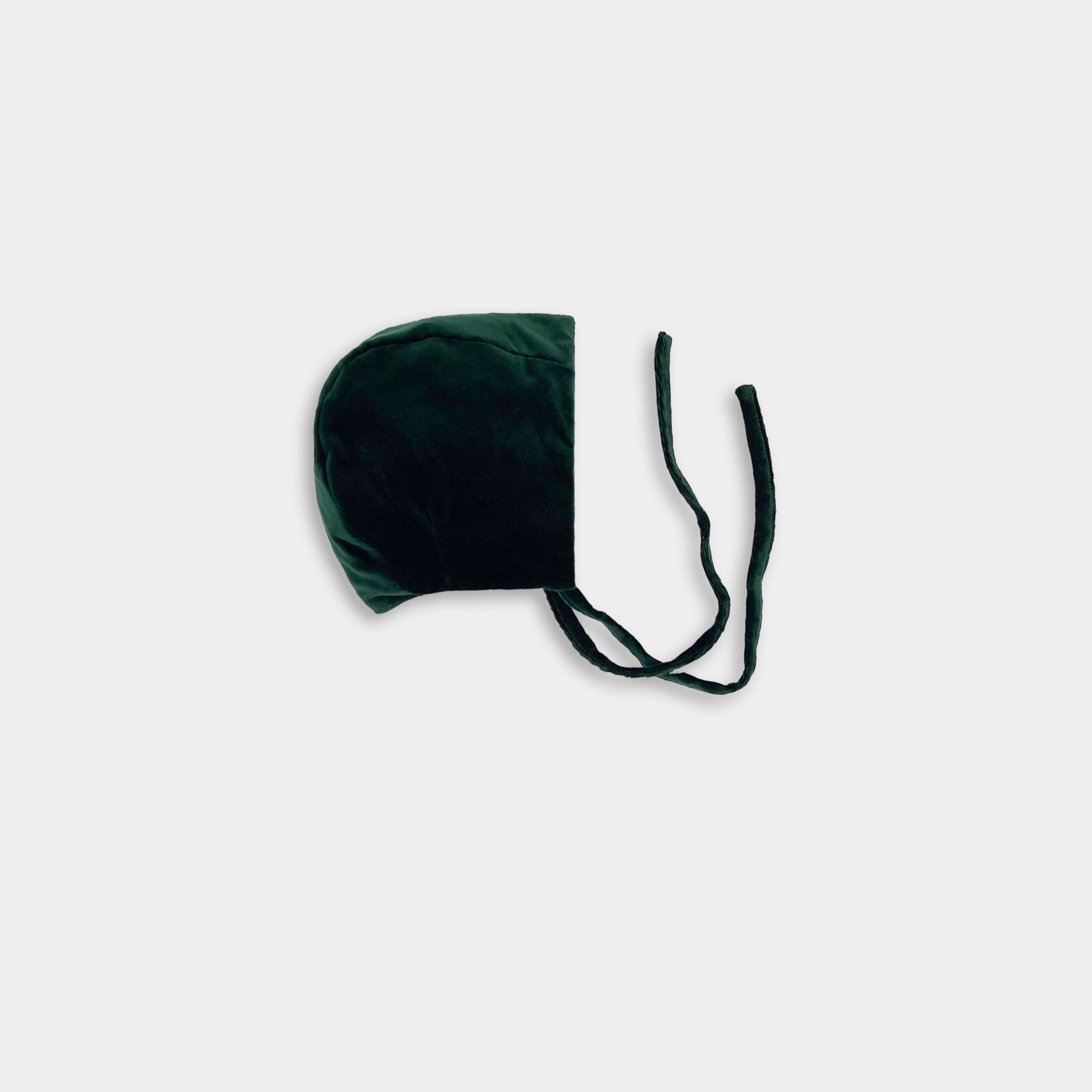 A green velvet bonnet with a soft brushed gingham cotton interior, displayed against a white background.
