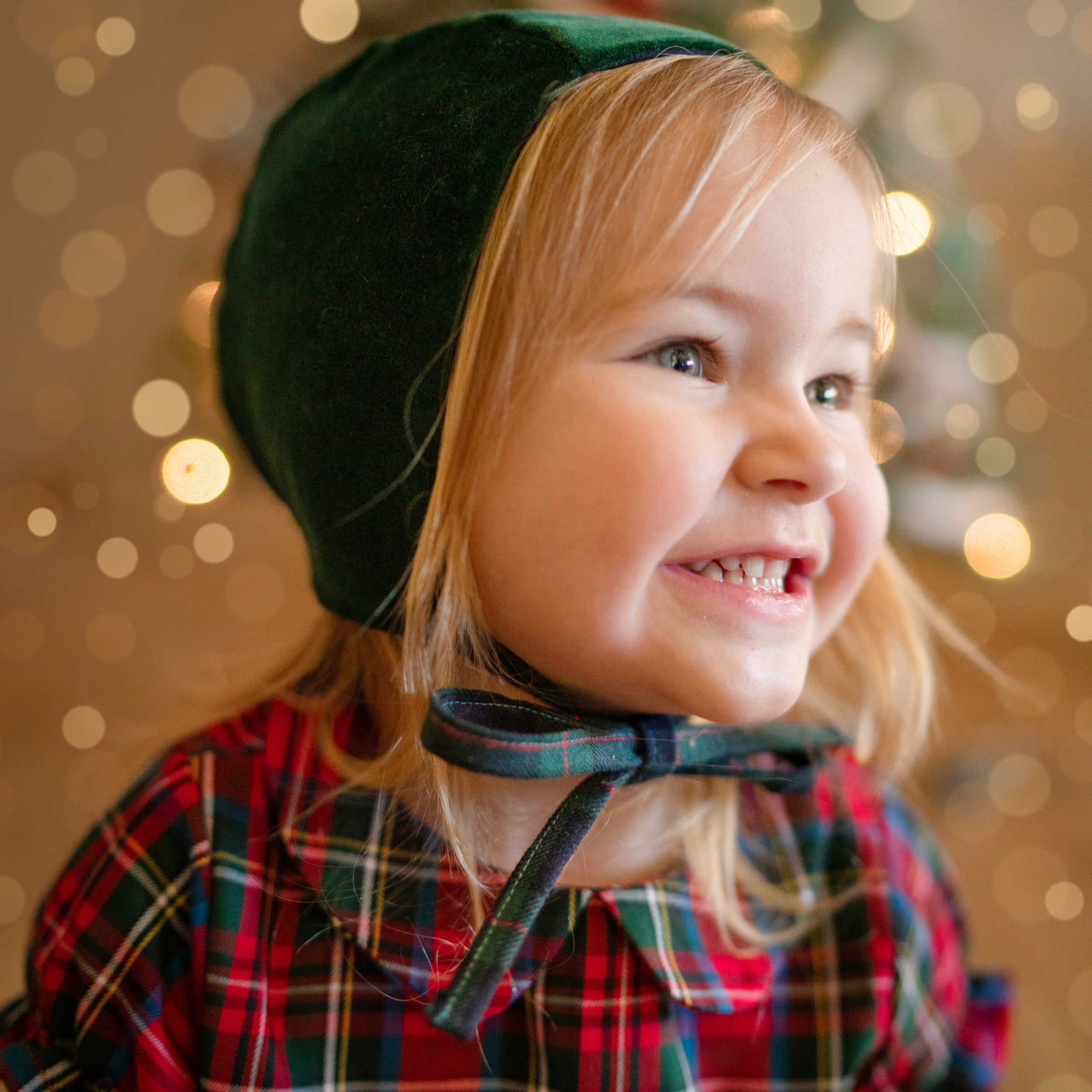 Girl in green bonnet smiling