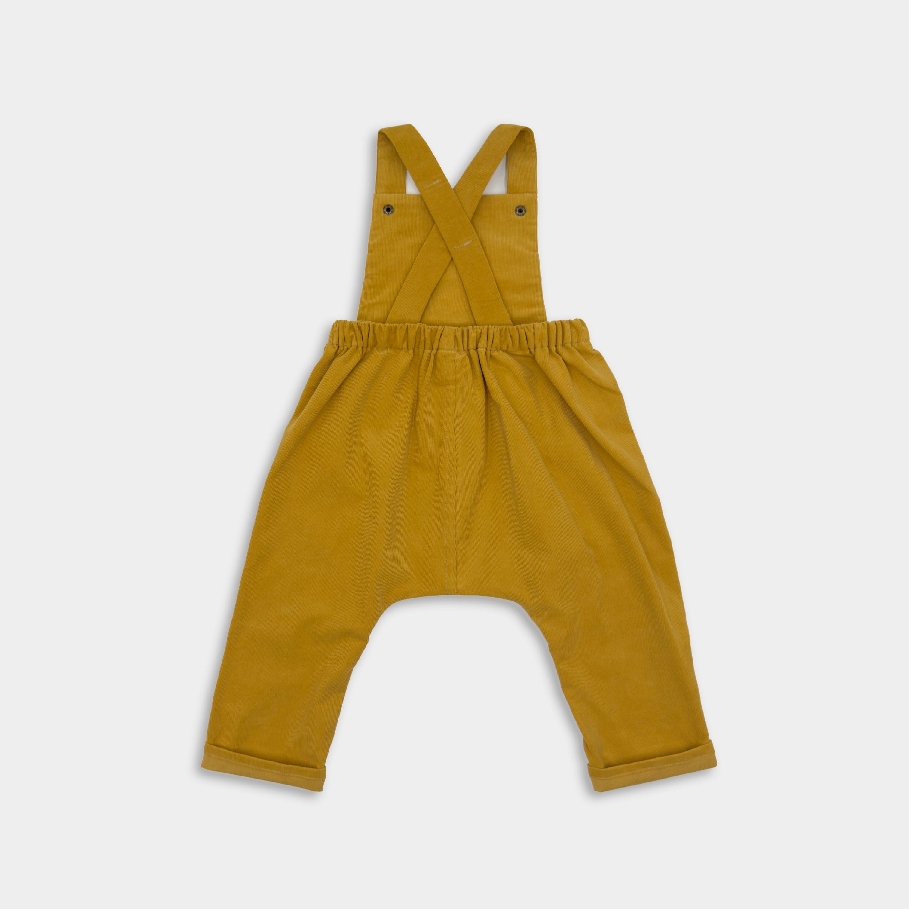 Back view of the Ginger Long Overalls alone, highlighting the craftsmanship and fabric quality, the comfortable drop-crotch shape and the roll up cuff for growth.