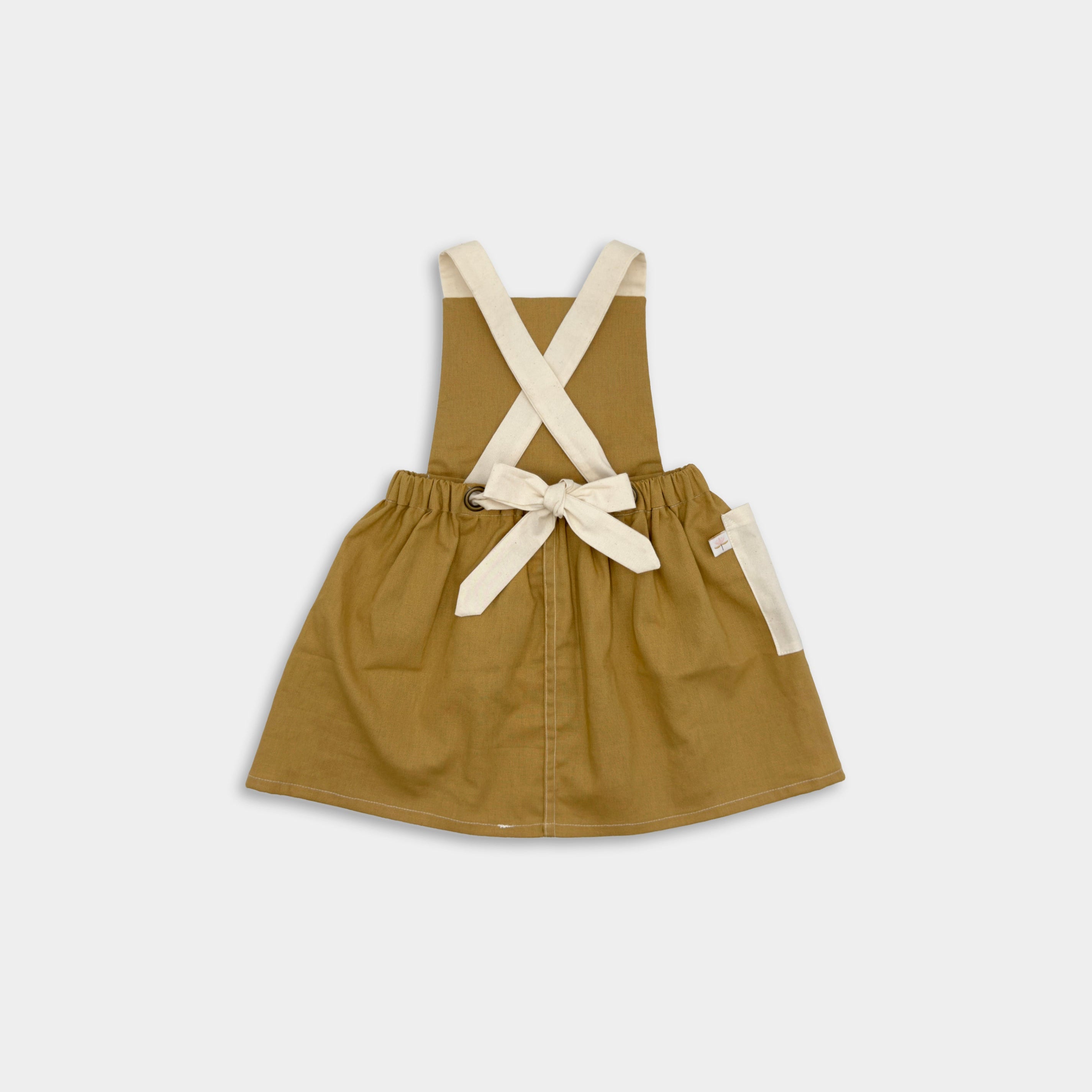 Back view of the Pinafore on its own: The back of the Pinafore - Honey displayed alone, focusing on the stitching, the contrasting straps and generous side pocket.