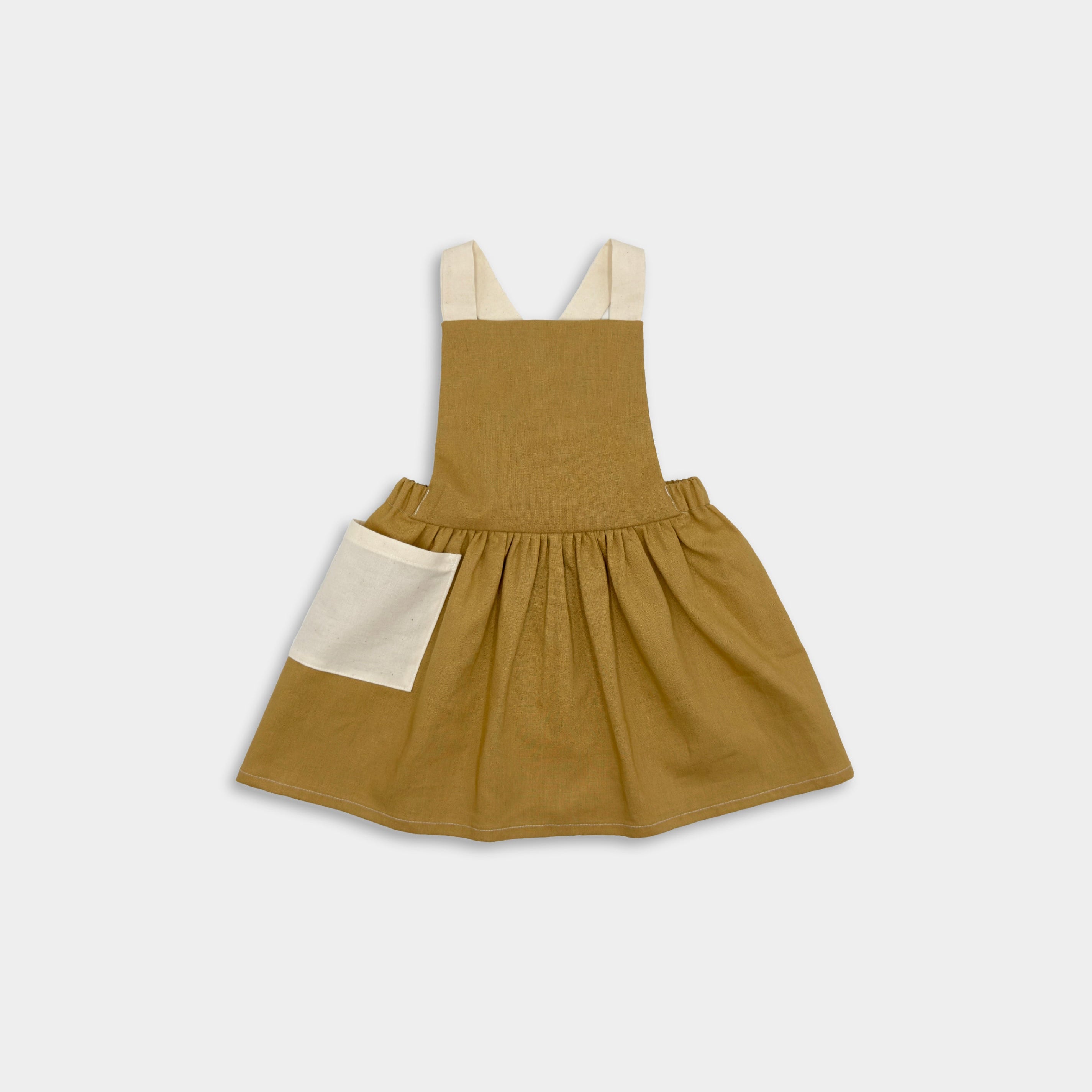 Front view of the Pinafore - Honey: A classic, handmade pinafore in a warm honey color, showcasing its timeless design with no top required, ideal for summer wear.