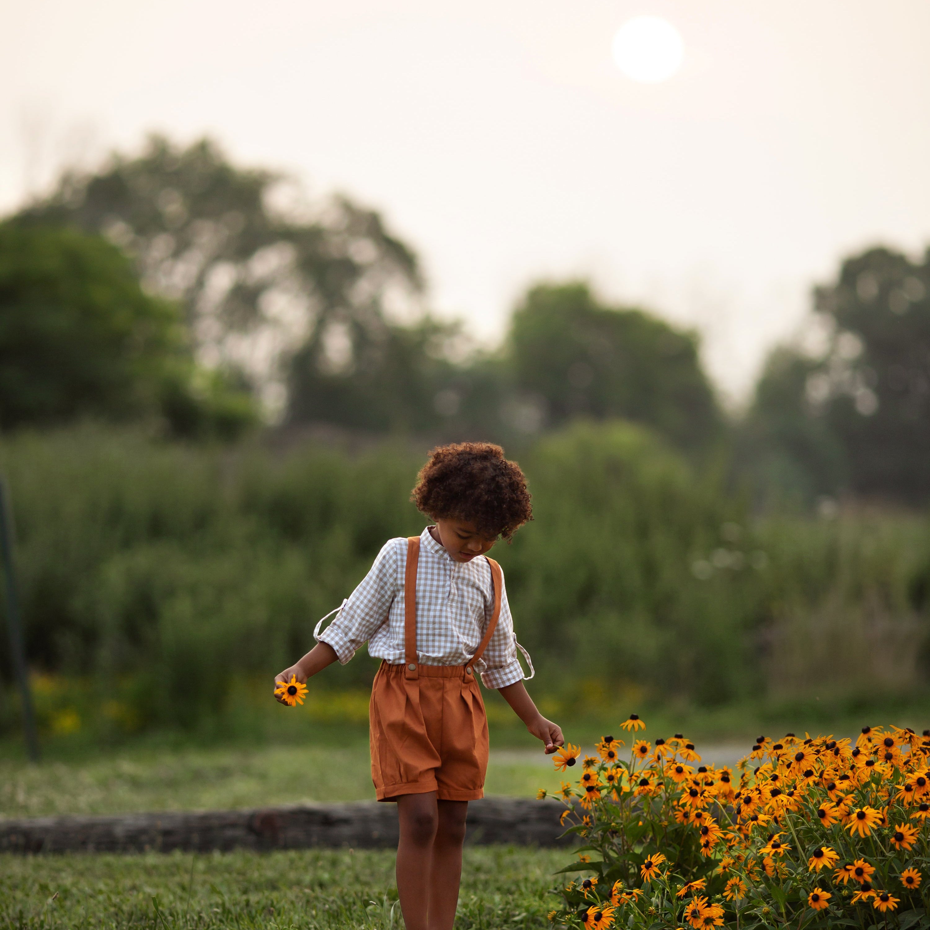 Model boy wearing the Burnt Orange Suspender Shorts with Beige Gingham Henley Shirt, front view - This image features the model showcasing the front of the outfit, highlighting the stylish combination of the shorts and henley shirt.