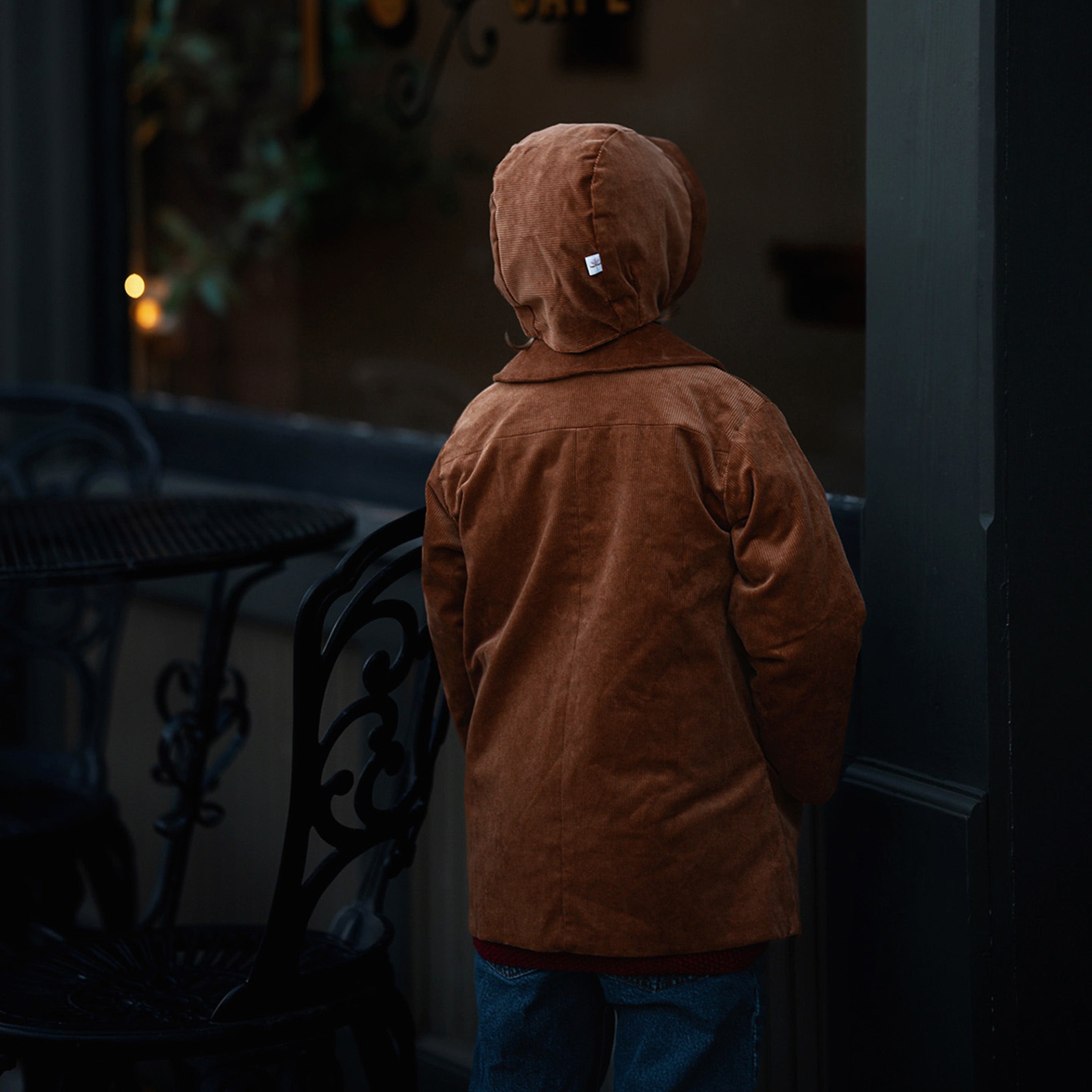 Back View with Bonnet: Back view of little boy in the Camel coat and bonnet, emphasizing the coat’s durability and timeless appeal for eco-conscious families.