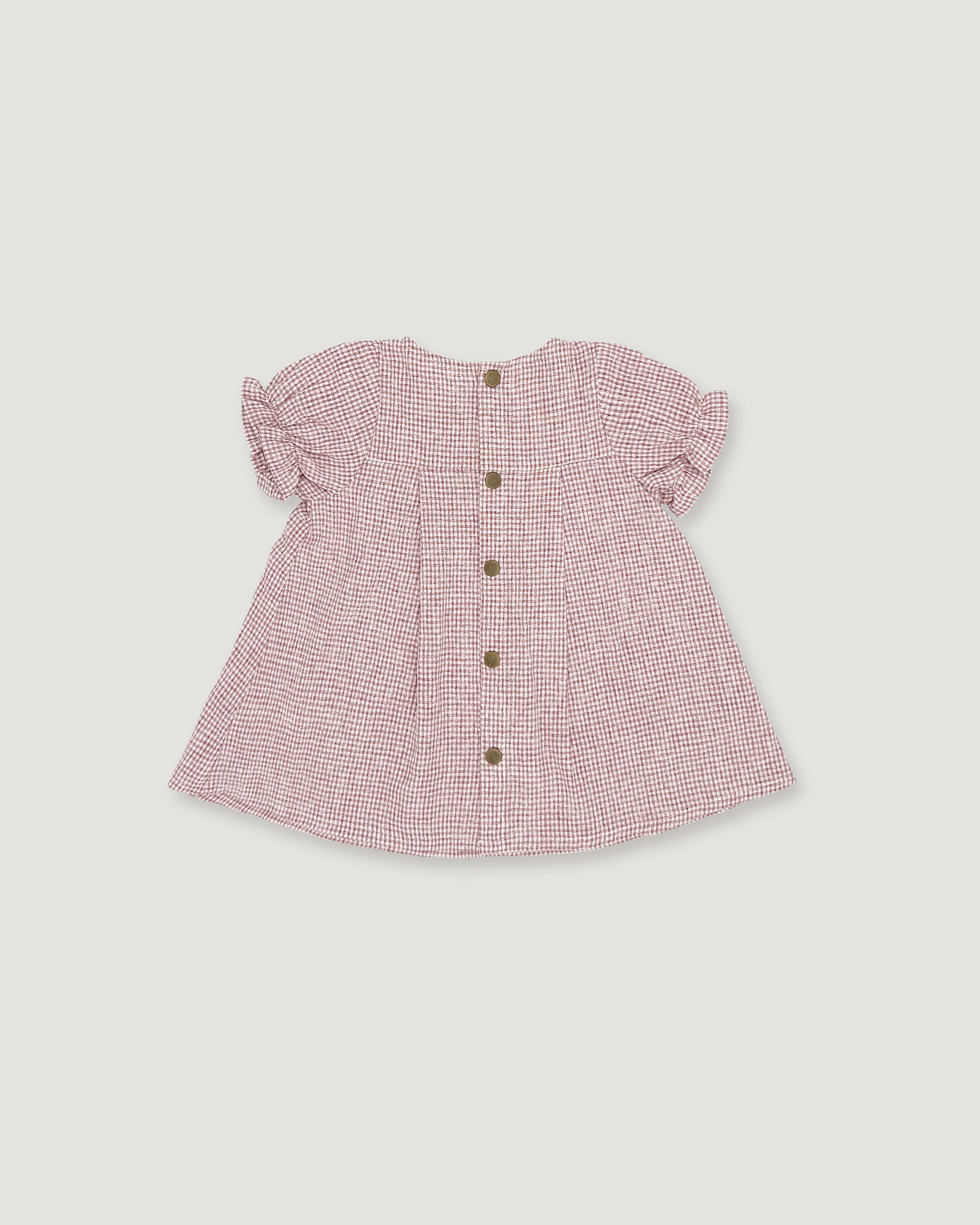 A pink and white gingham baby top with short ruffled sleeves and a button-up front, shown flat on a light gray background.