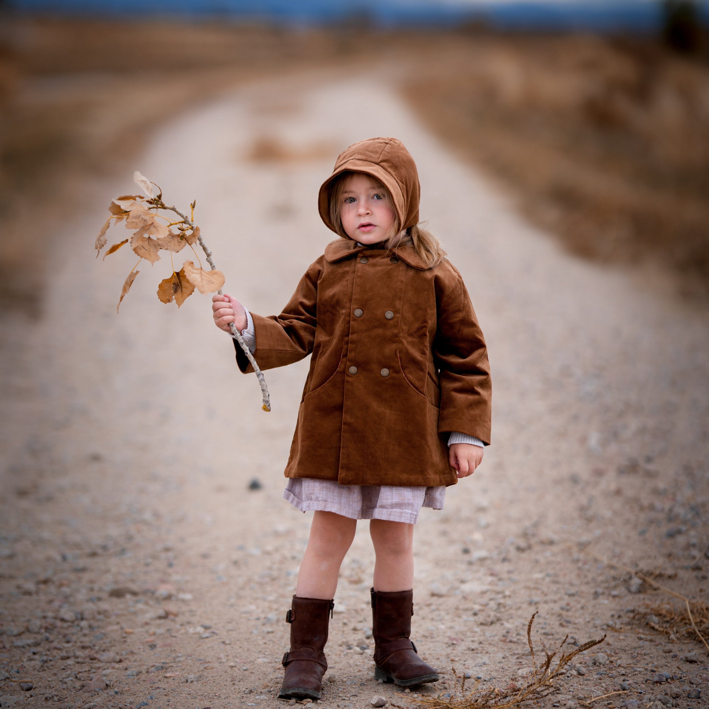 Model girl wearing the Camel Bonnet, front view - This image features the model showcasing the bonnet from the front, highlighting its snug fit and timeless style on the little one.