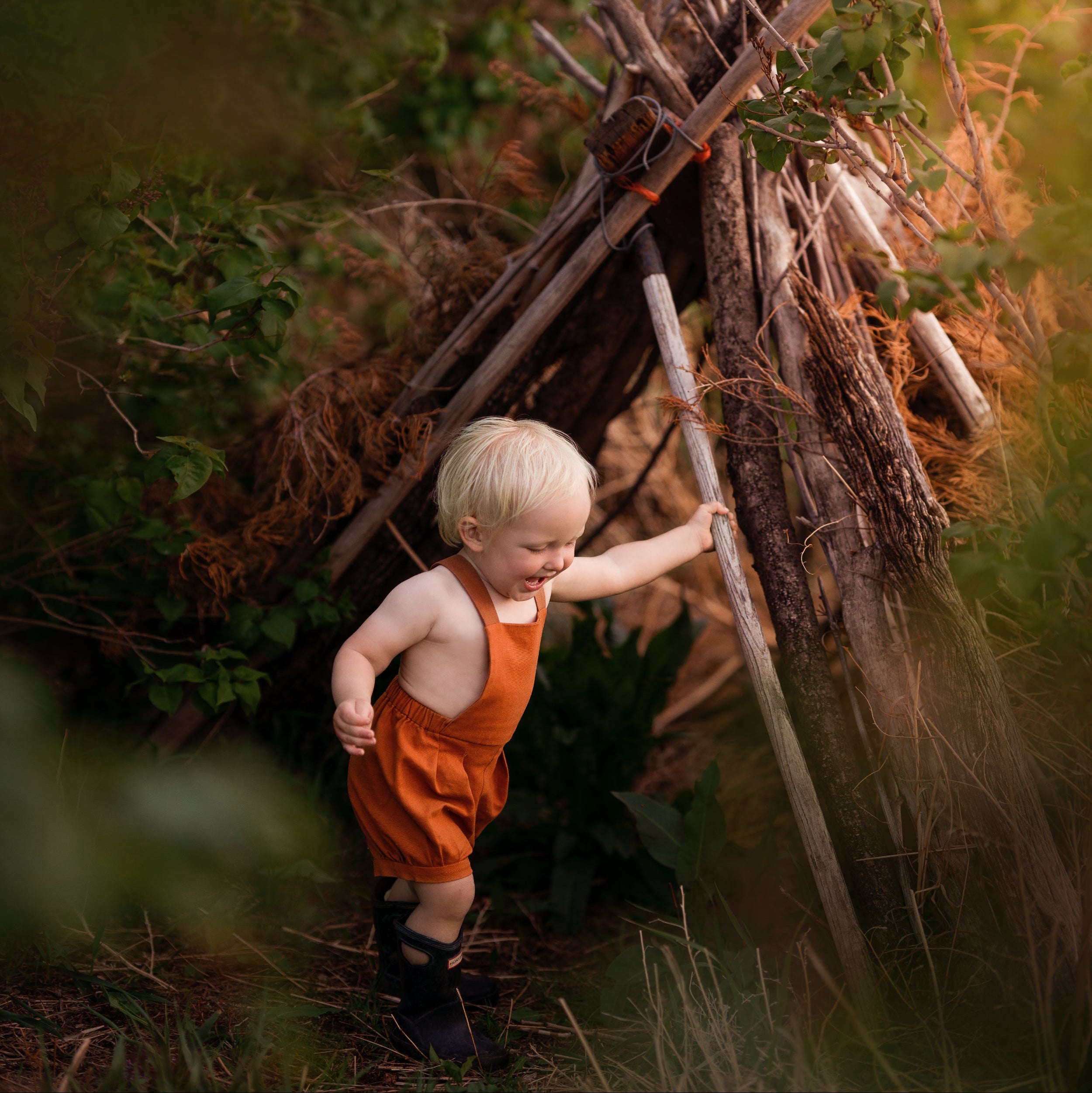 Model boy playing in Burnt Orange Short Overalls - This dynamic photo captures the boy in action, emphasizing the versatility and all-day comfort of the shortalls while he enjoys his playtime.
