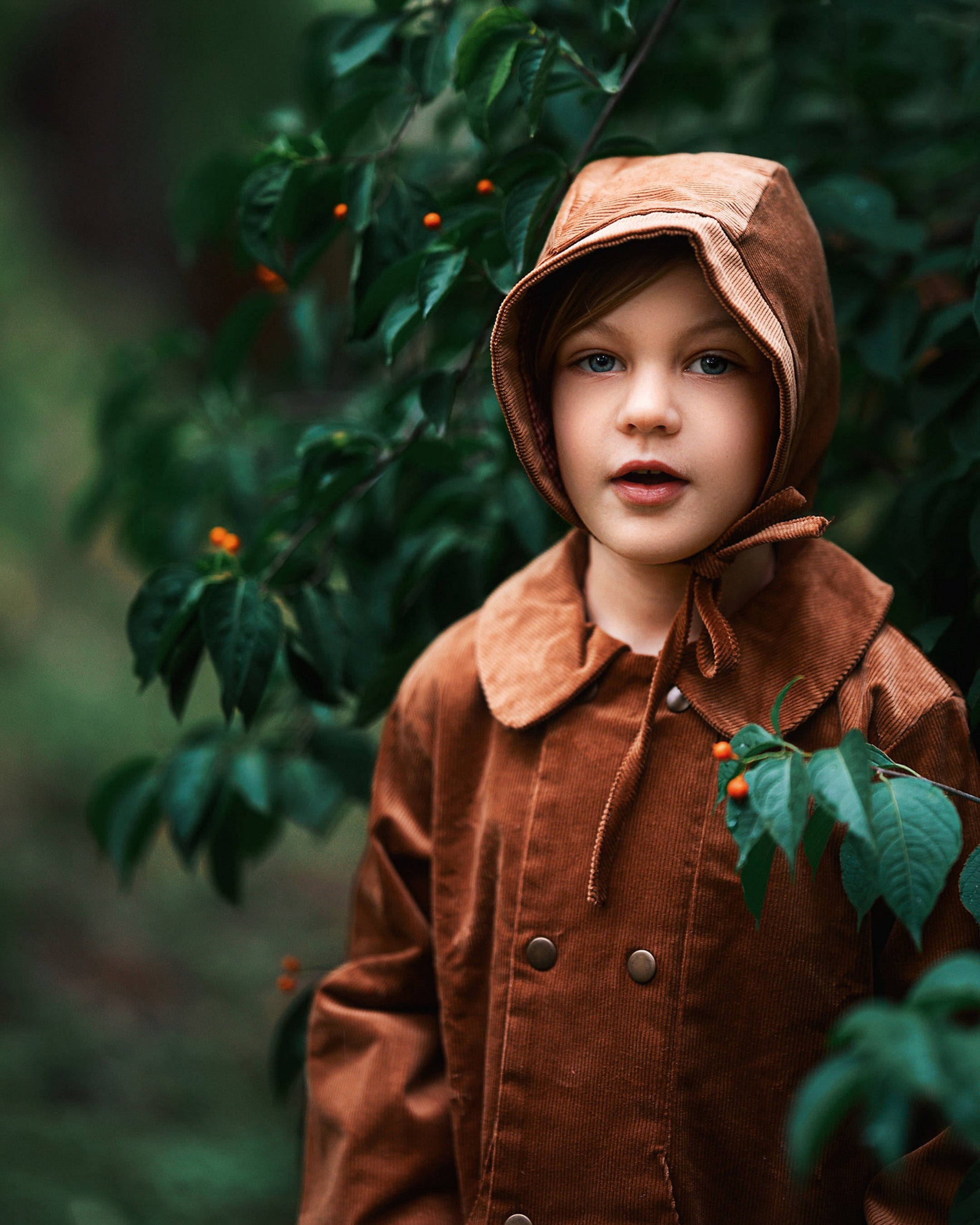 A close-up view of the Camel coat on a boy model. It reveals the snap closures and Peter Pan collar, ensuring comfort for kids while promoting eco-friendly fashion.