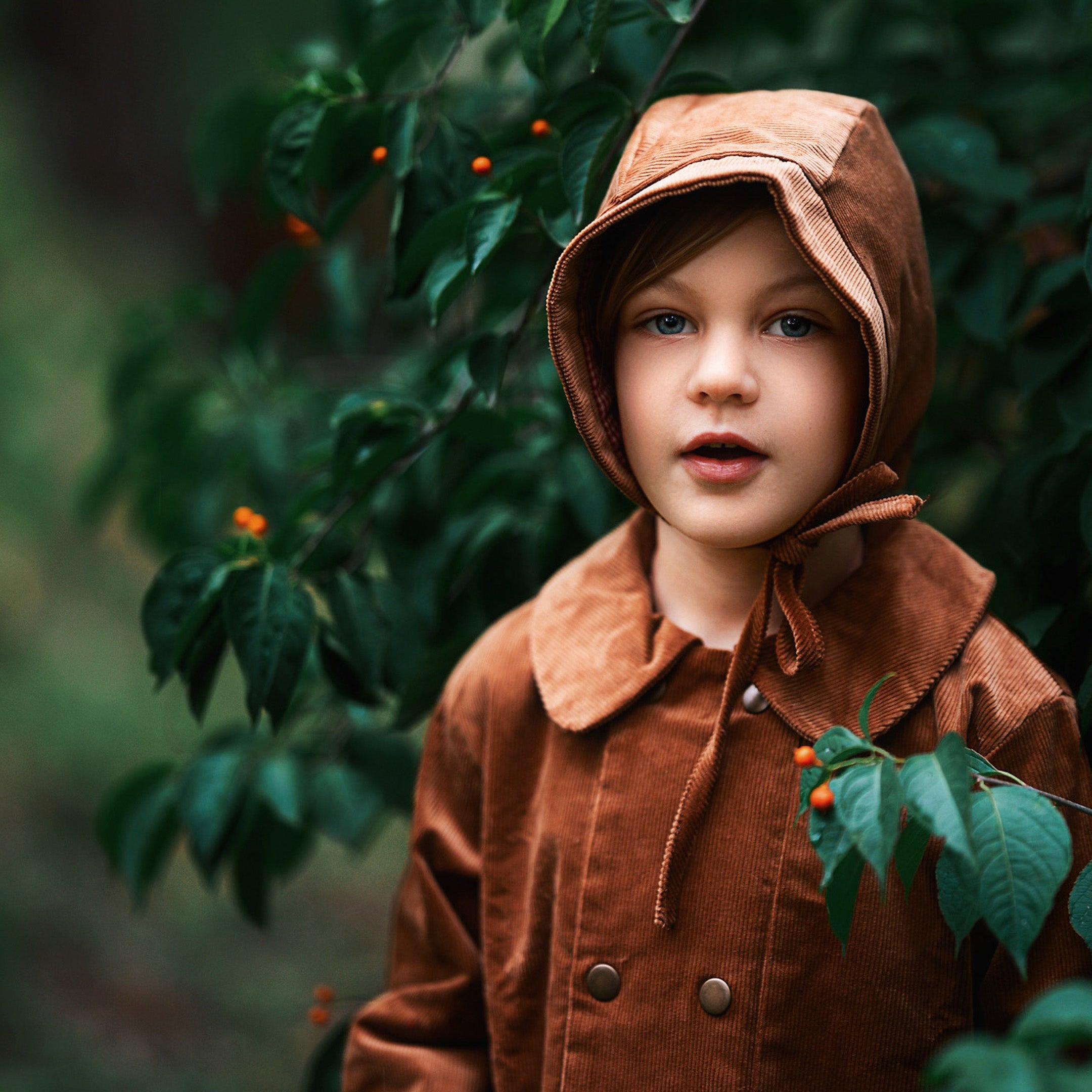 A close-up view of the Camel coat on a boy model. It reveals the snap closures and Peter Pan collar, ensuring comfort for kids while promoting eco-friendly fashion.