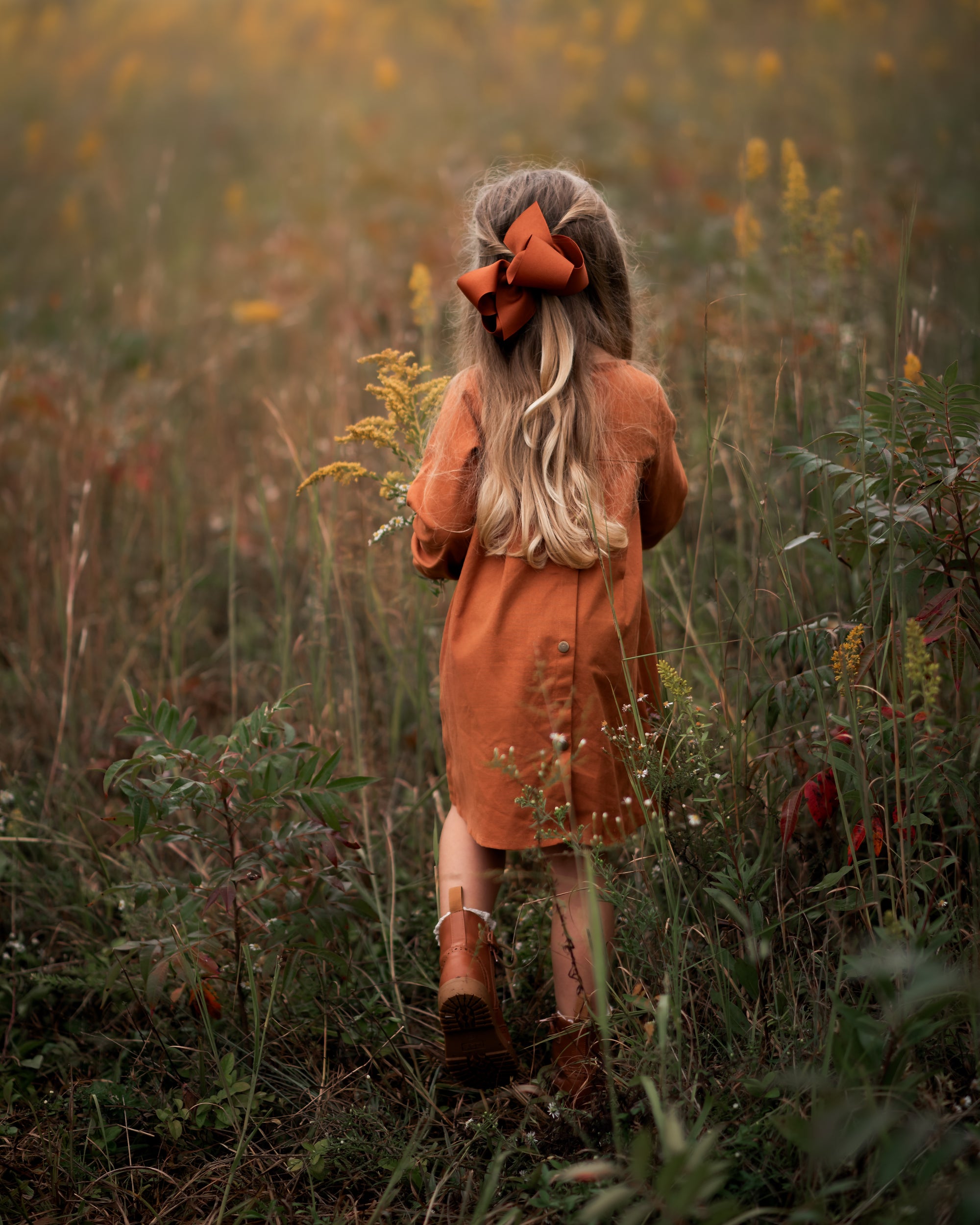 Model girl showcasing the back view of the dress - This image focuses on the back of the dress, showcasing the pleated yoke and how it complements the overall design.