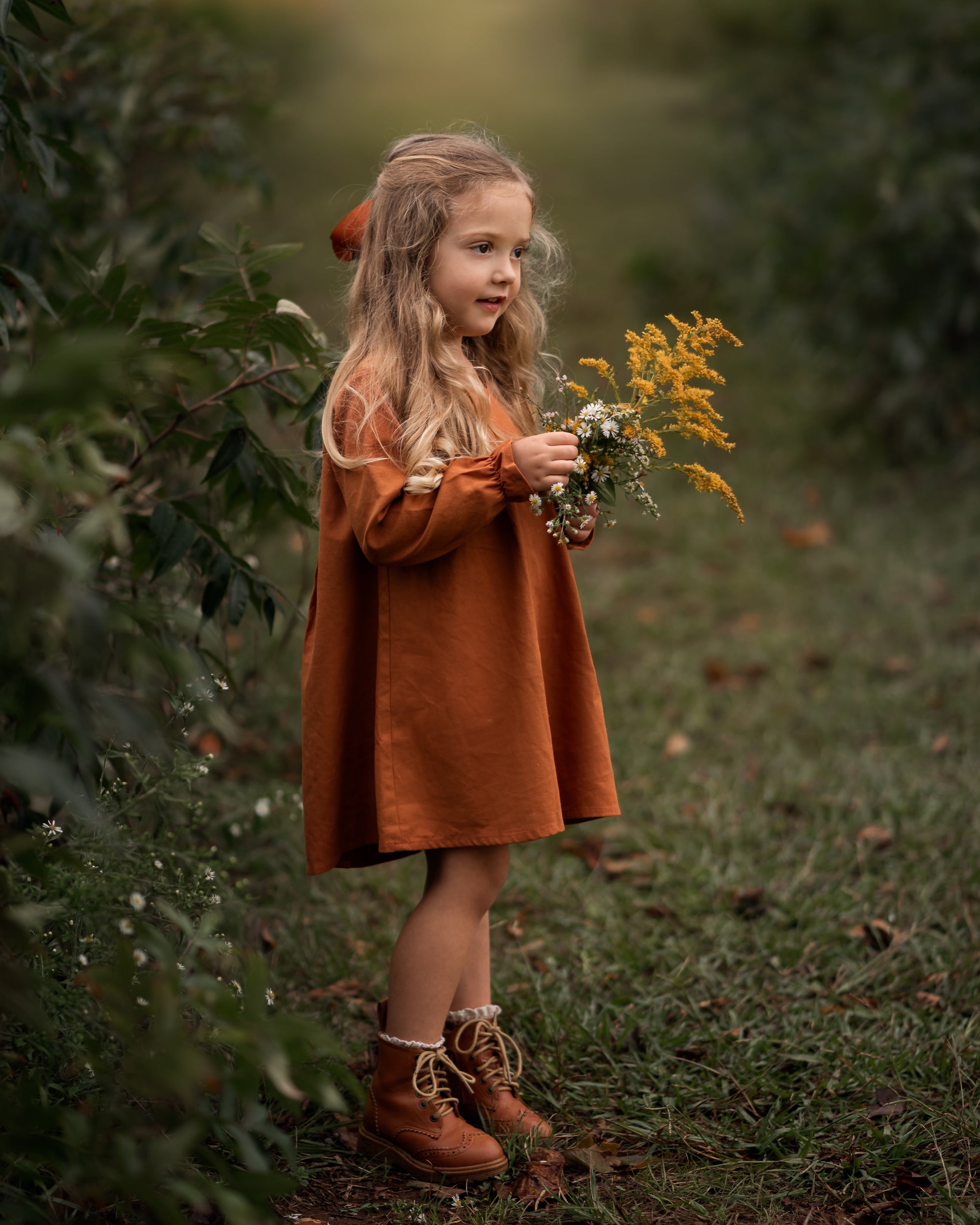 Model girl showcasing the side view of the dress - This side angle captures the dress’s flow and movement, emphasizing the ruffled hem at the sleeves and the overall fit.