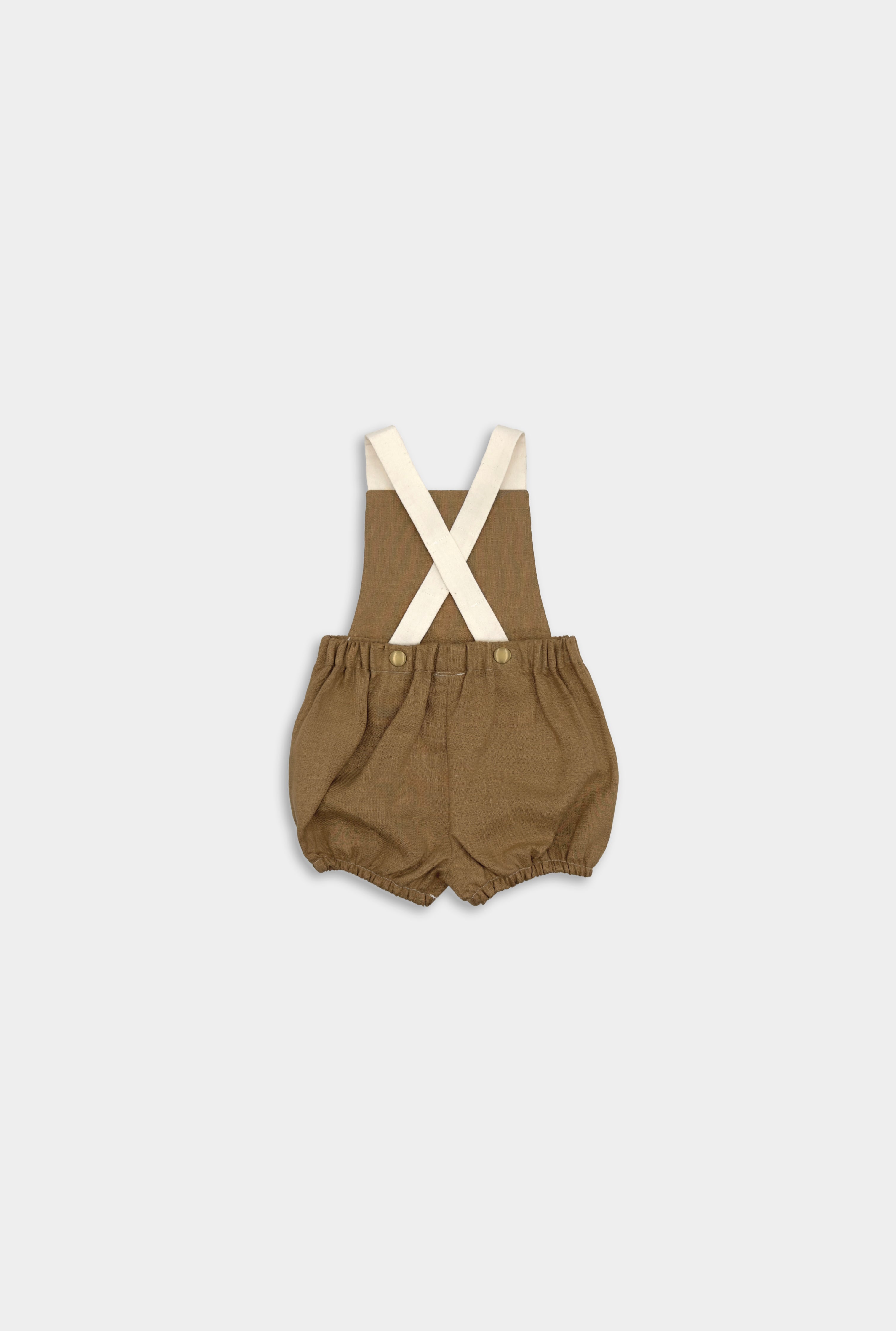 Back view of a handmade linen bubble romper in Beachwood, featuring adjustable contrasting straps in cream for a customizable fit and elasticized legs for easy movement during summer play. A gender-neutral design that combines timeless style with comfort, perfect for any occasion.