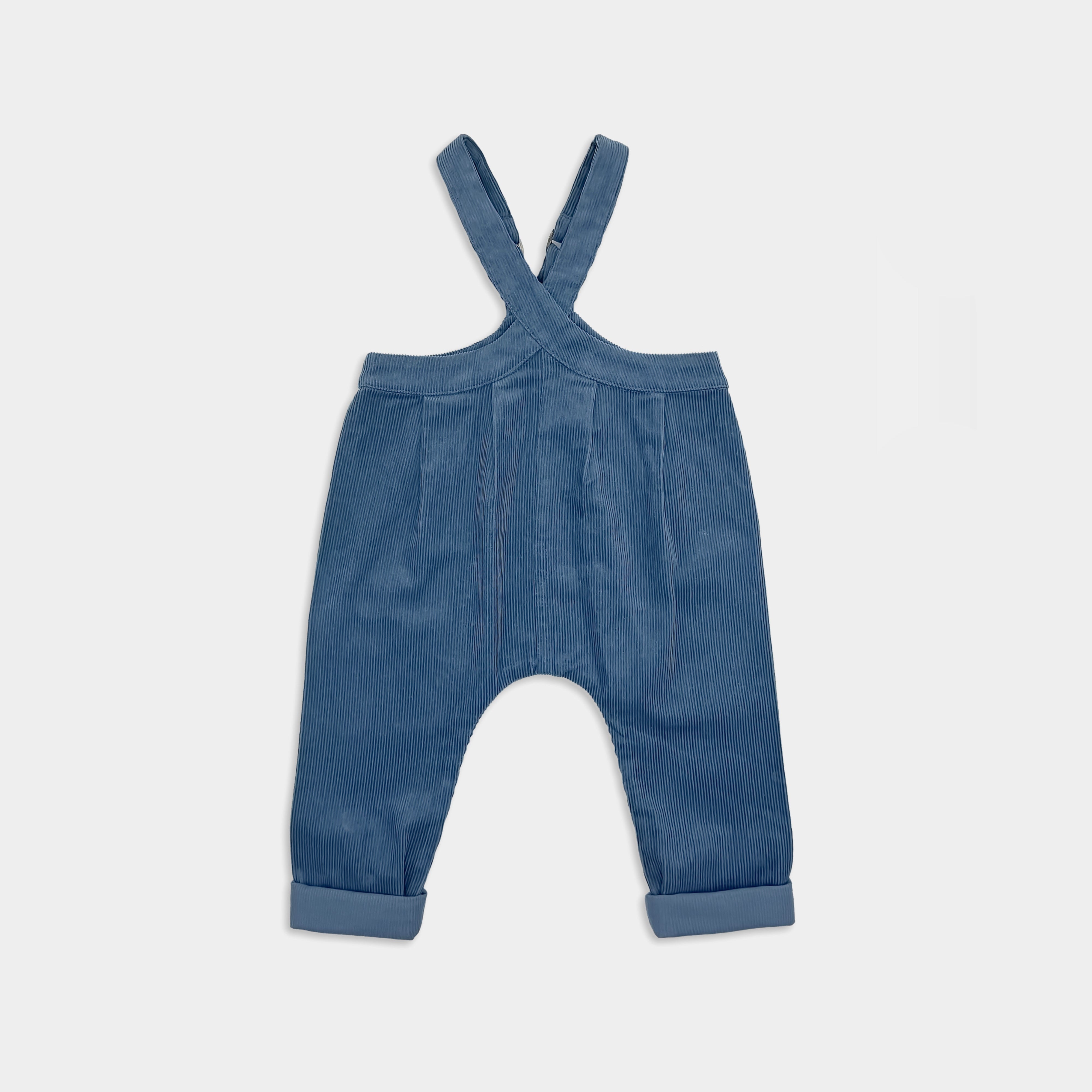 Blue denim corduroy overalls on a light gray background