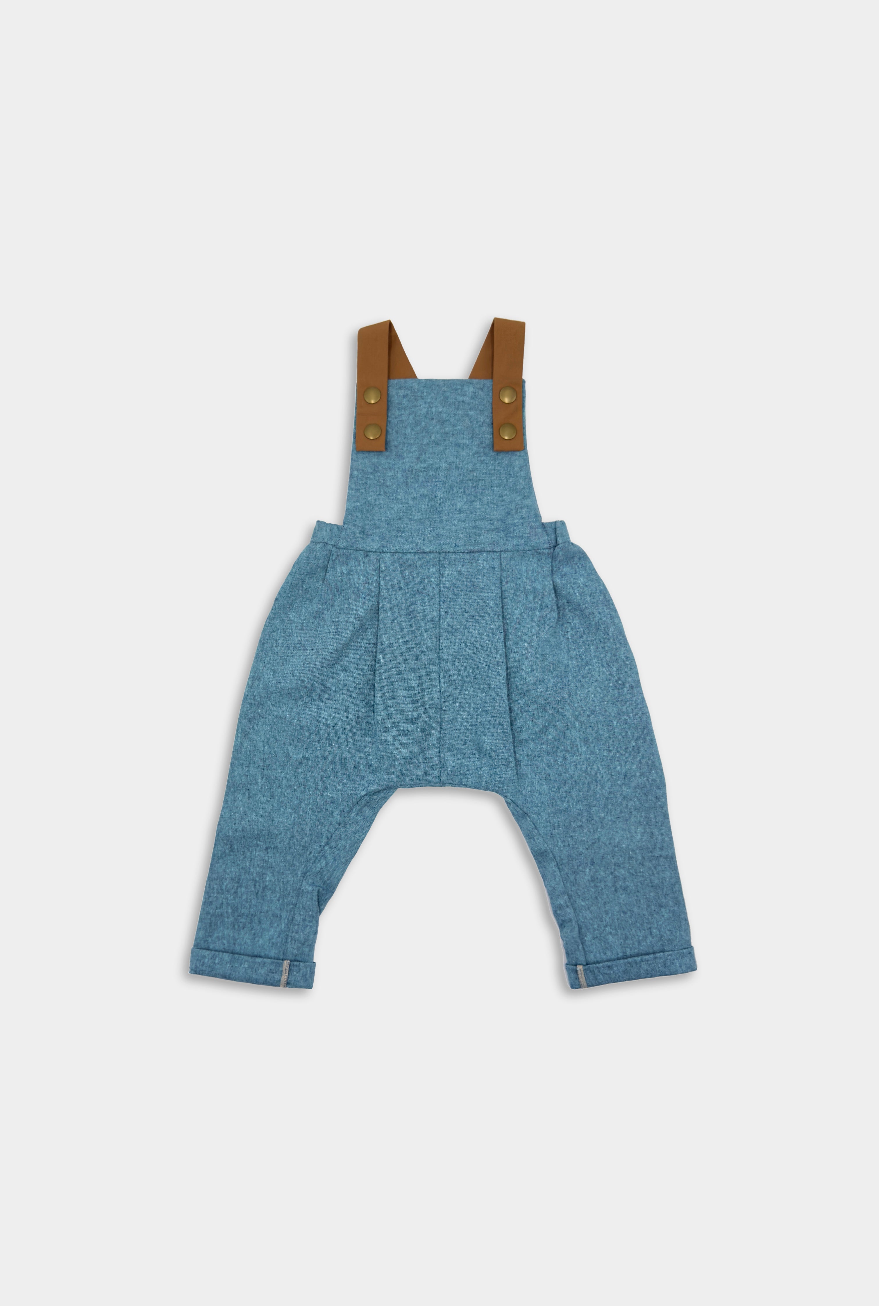 Blue Jay Long Overalls - Handmade from repurposed linen fabric, these gender-neutral overalls are perfect for passing down. The breathable fabric ensures all-day comfort, while stylish pleats add elegance to the design. Featuring leather-looking straps for enhanced durability and visual appeal, adjustable straps in two lengths provide a perfect fit. Unfoldable leg cuffs are designed to grow with your little one, making these overalls a versatile and sustainable choice for any wardrobe.