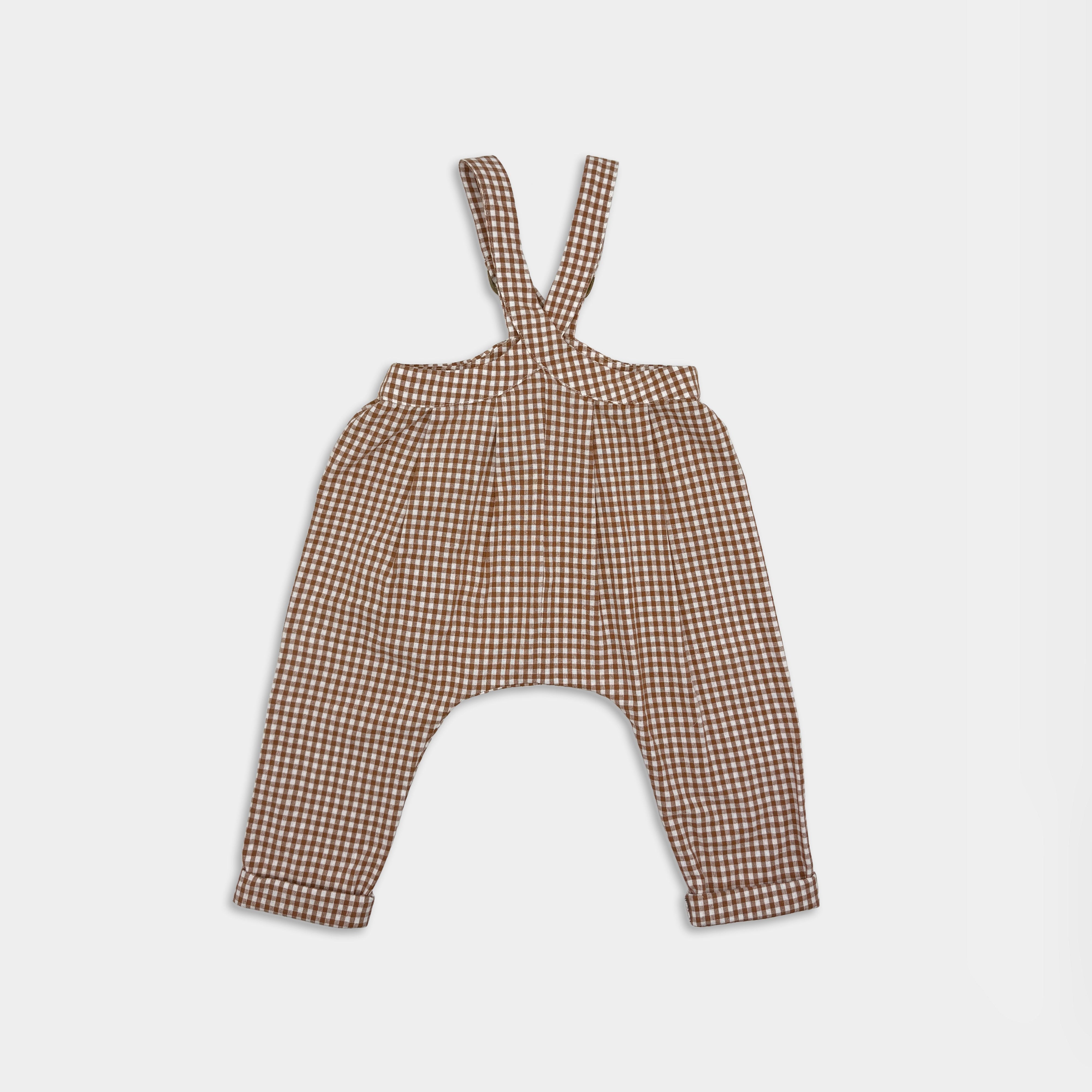 Front view of brown checkered romper with suspenders on a light grey  background