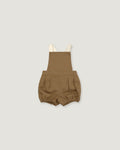 A pair of toddler's linen bubble shorts in a warm brownish-tan color, featuring adjustable cream-colored shoulder straps, shown flat on a light gray background.