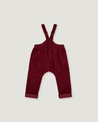 A pair of baby corduroy suspenders in deep burgundy, featuring adjustable shoulder straps and rolled cuffs, laid flat against a light gray background.
