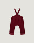 A pair of toddler's burgundy corduroy overall pants with adjustable shoulder straps and rolled cuffs, shown flat on a light gray background.