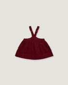 A dark burgundy baby girl's overall dress with adjustable shoulder straps, shown flat against a light gray background.