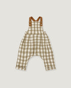 A baby romper in a beige and white gingham check pattern with brown shoulder straps, displayed flat against a light gray background.