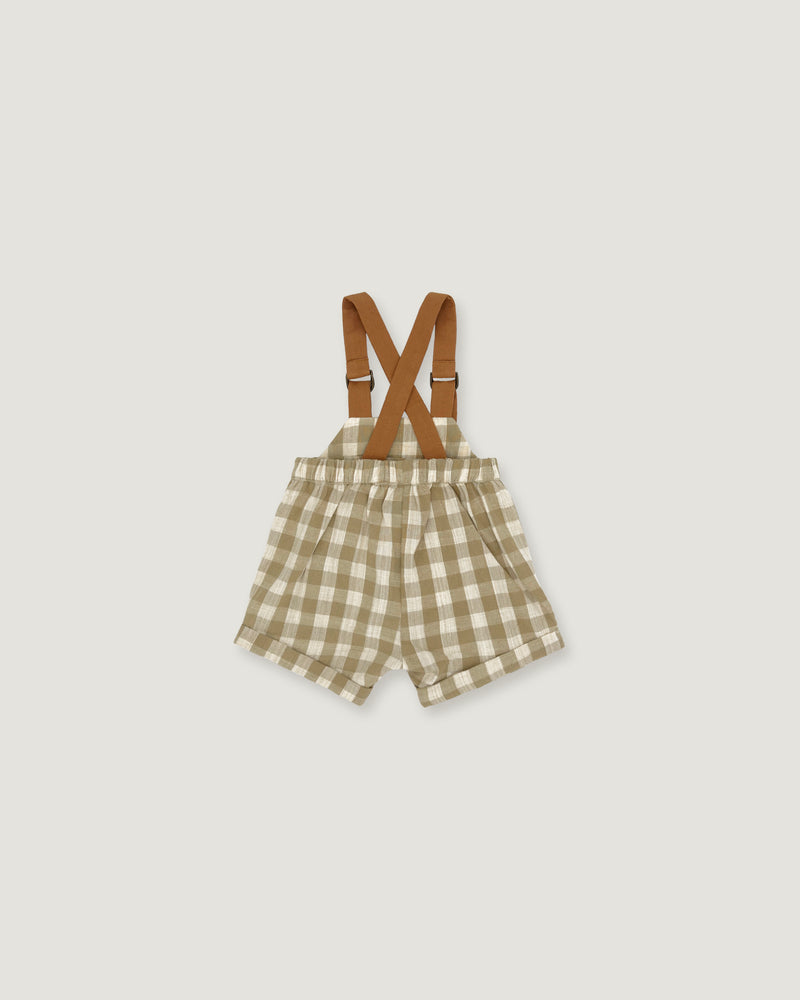 A pair of toddler boy's shorts in a beige and white gingham check pattern, featuring brown adjustable suspenders with metal clasps, laid flat on a light gray background.