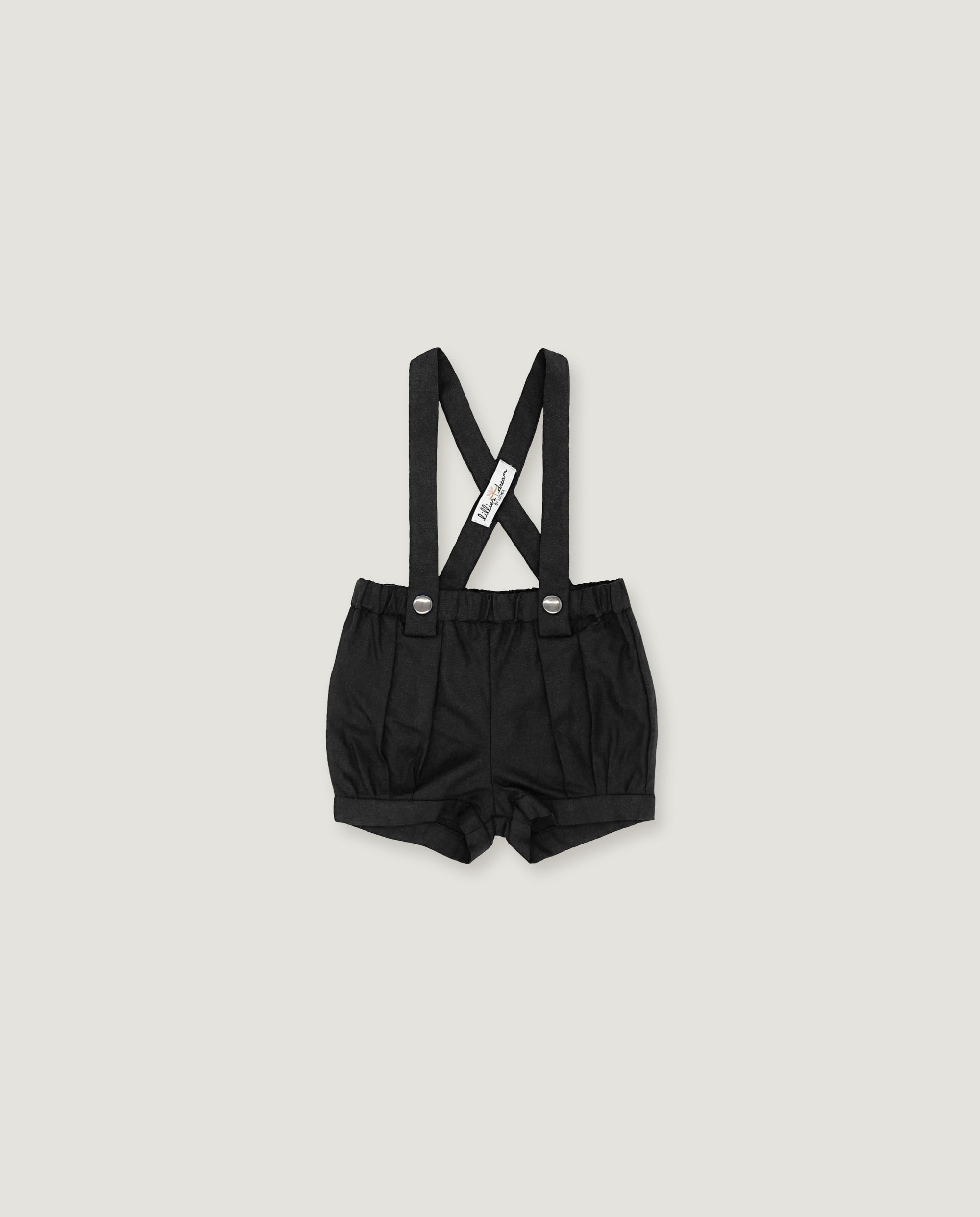 Black baby boy's suspenders shorts with adjustable shoulder straps and a white brand tag, shown flat on a light gray background.