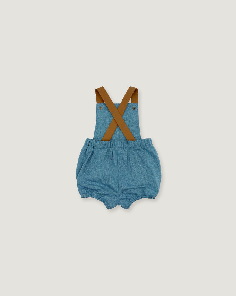 A pair of baby denim bubble shorts with brown suspenders, laid flat on a light gray background.