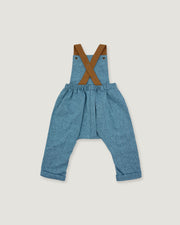 A pair of toddler's blue denim overall-style pants with brown suspenders, laid flat on a light gray background.