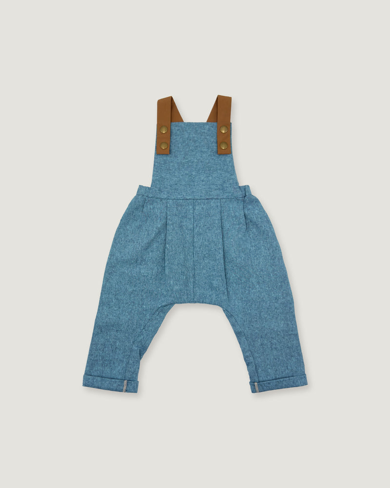 A pair of baby blue denim overall-style pants with brown shoulder straps and brass-tone buttons, shown flat against a light gray background.