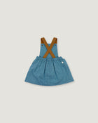 A toddler girl's denim overall dress with brown faux-leather suspenders, shown flat on a light gray background.