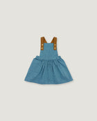 A toddler girl's blue denim overall dress with brown fabric shoulder straps and gold-tone buttons, shown flat on a light gray background.