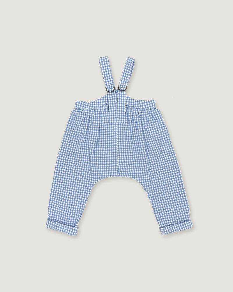 A pair of baby boy's blue and white gingham check suspenders with adjustable straps and a drawstring waist, laid flat on a light beige background.